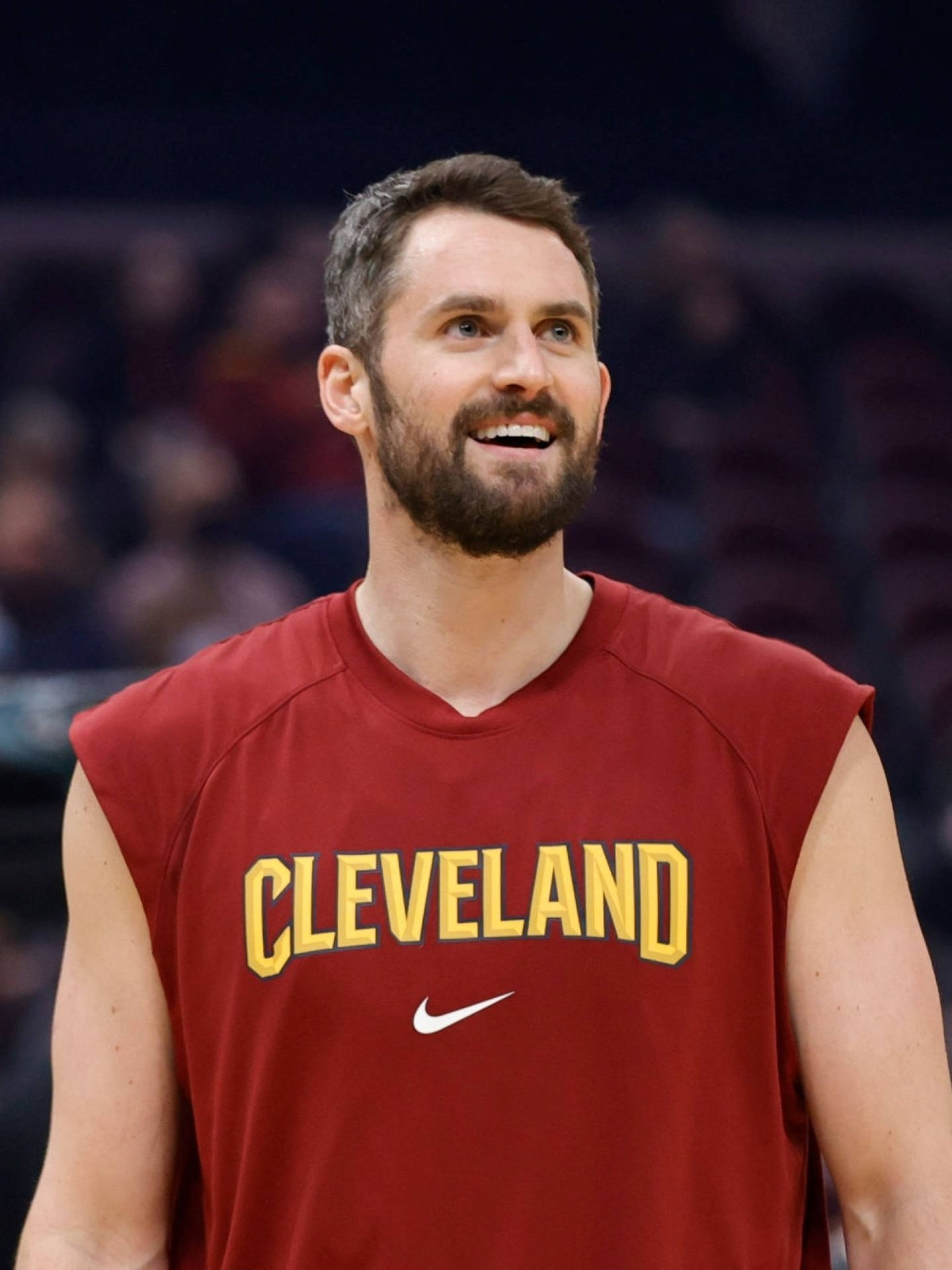 2022 NBA 凱文·樂福 壁紙 — 一位微笑的籃球運動員身穿紅色克里夫蘭練習球衣，帶著喜悅的表情向上看。