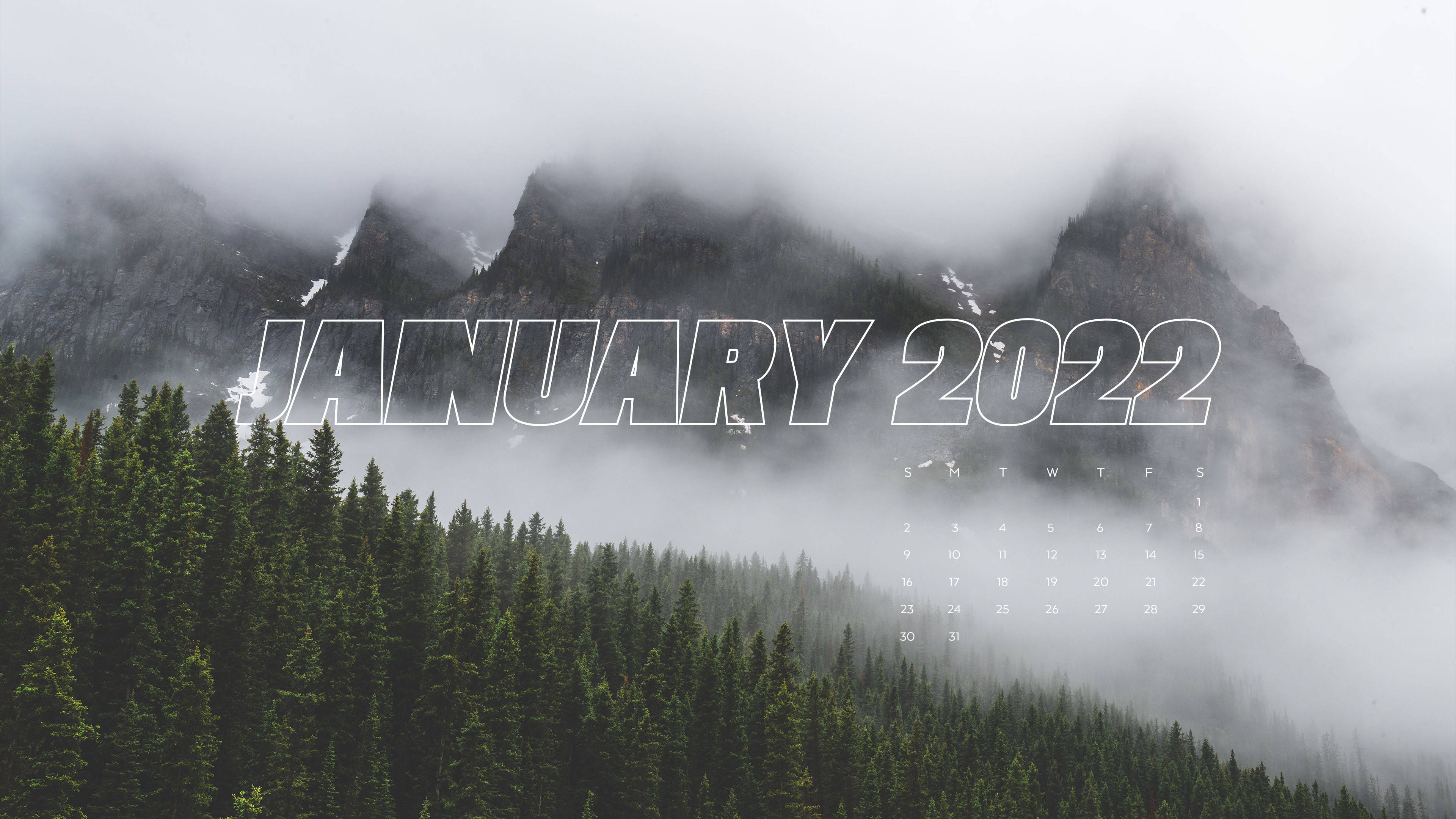 2022年1月霧山 壁紙 — 霧氣籠罩的山峰聳立在茂密的常綠森林之上，並帶有2022年1月的日曆疊加。