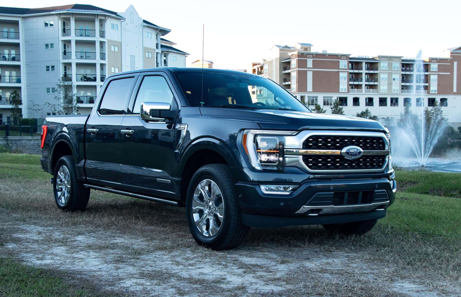 黑色福特F-150皮卡車停在公寓大樓前的噴泉附近。