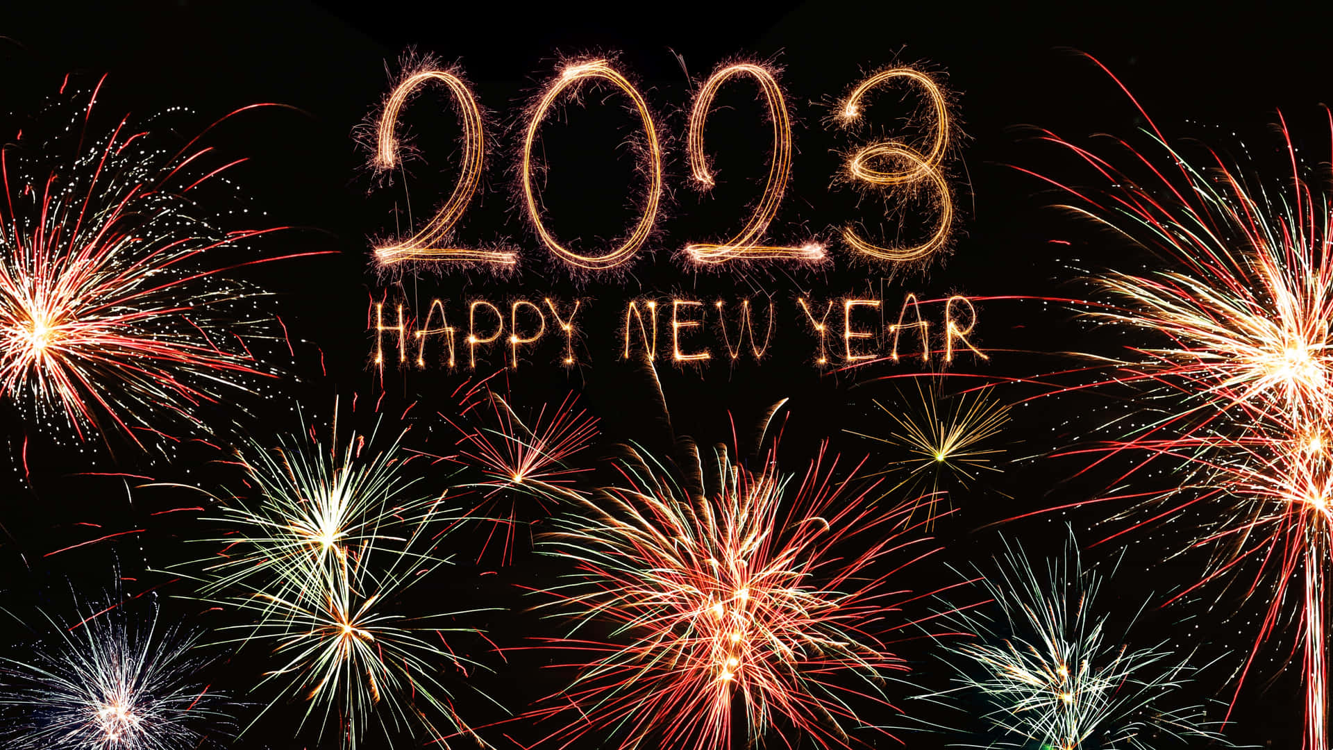 煙火在發光的金色文字周圍爆炸，文字寫著 2023 Happy New Year。