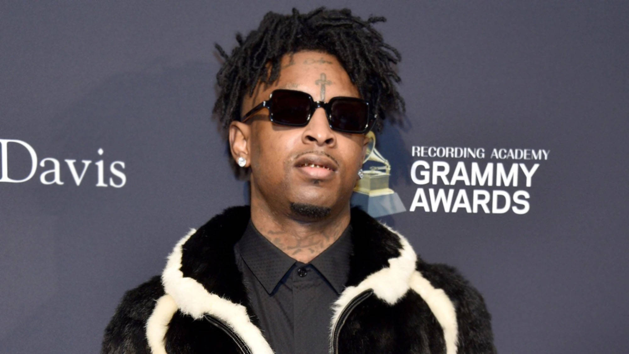 21 Savage 出席第62屆格萊美獎 壁紙 — 一名留著辮子頭、戴著太陽眼鏡的男子，在格林美獎紅地毯上穿著黑白皮草大衣。