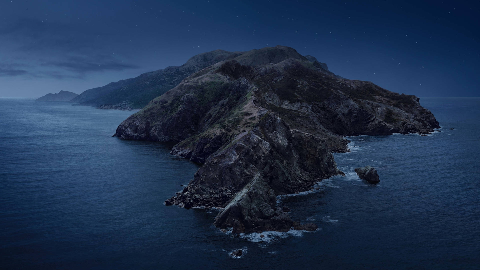 夜晚的岩石島嶼，上方有星星，海浪拍打海岸。