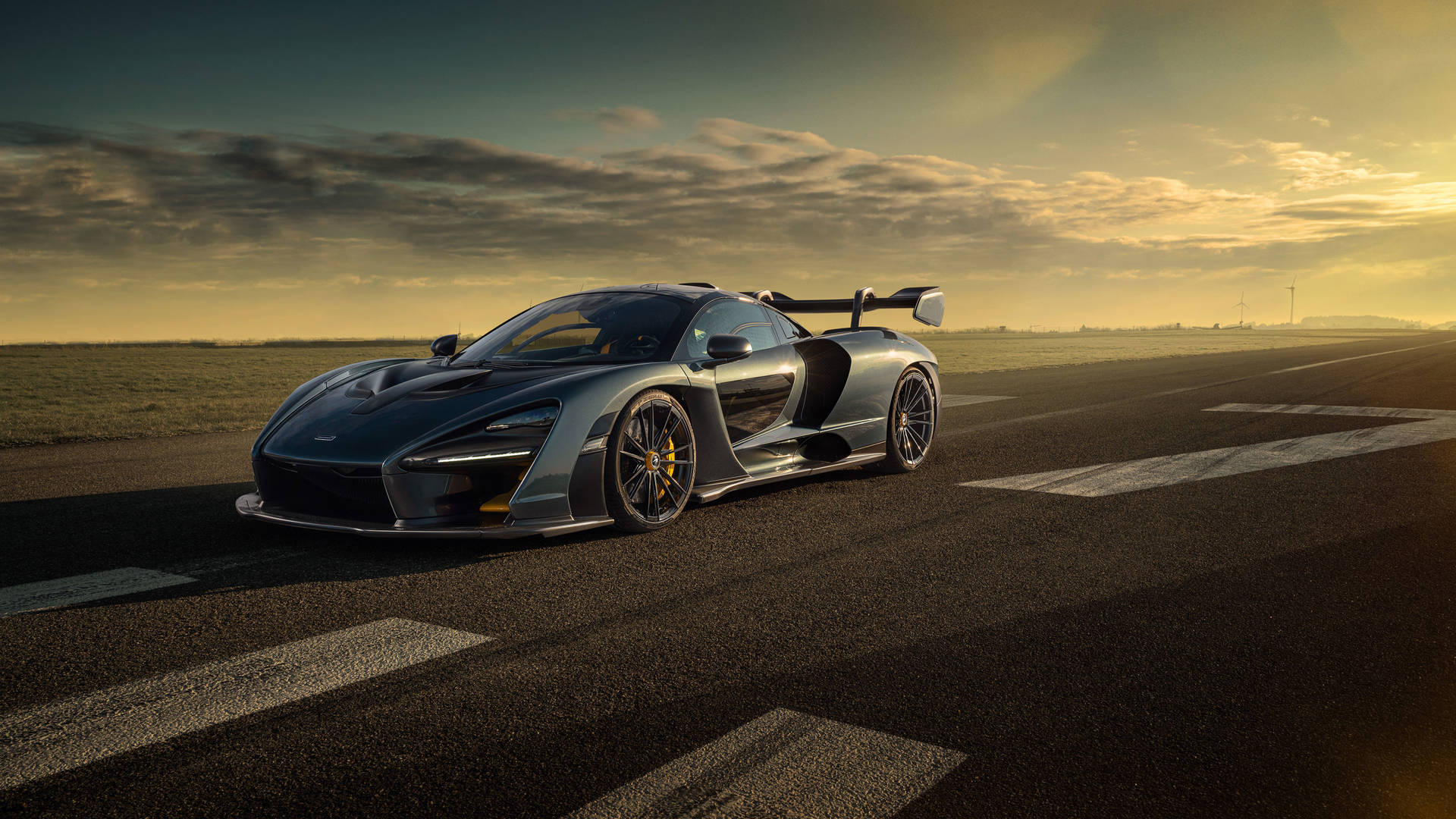 日落時分，銀色McLaren Senna停在跑道上，天空充滿戲劇性。