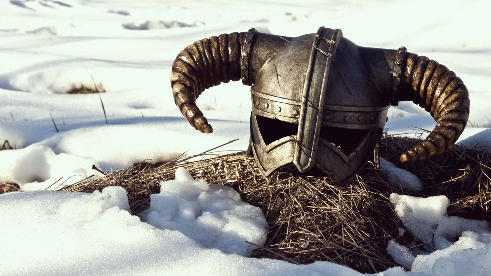 一個生鏽的有角騎士頭盔，埋在雪和乾草中。 — 維京人 GIF 壁紙