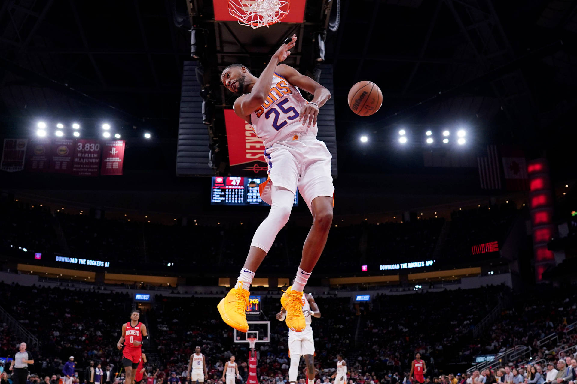25號 NBA 明星 米卡爾·布里奇斯 壁紙 — 一名身穿白色球衣的籃球運動員在場館燈光下穿著亮黃色鞋子高高躍起灌籃。