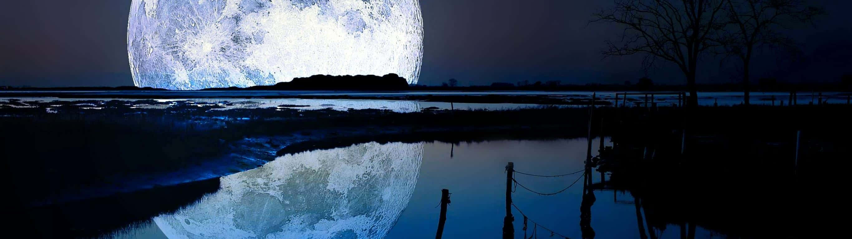 在漆黑的夜空下，一輪巨大的月亮倒映在平靜的水面上。
