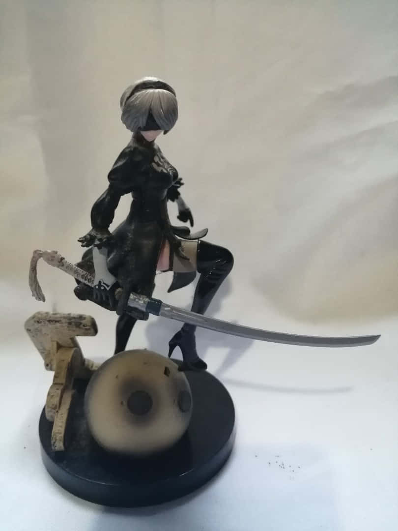動漫人偶，銀髮女戰士手持武士刀，站在帶有骷髏頭和木頭的黑色底座上。
