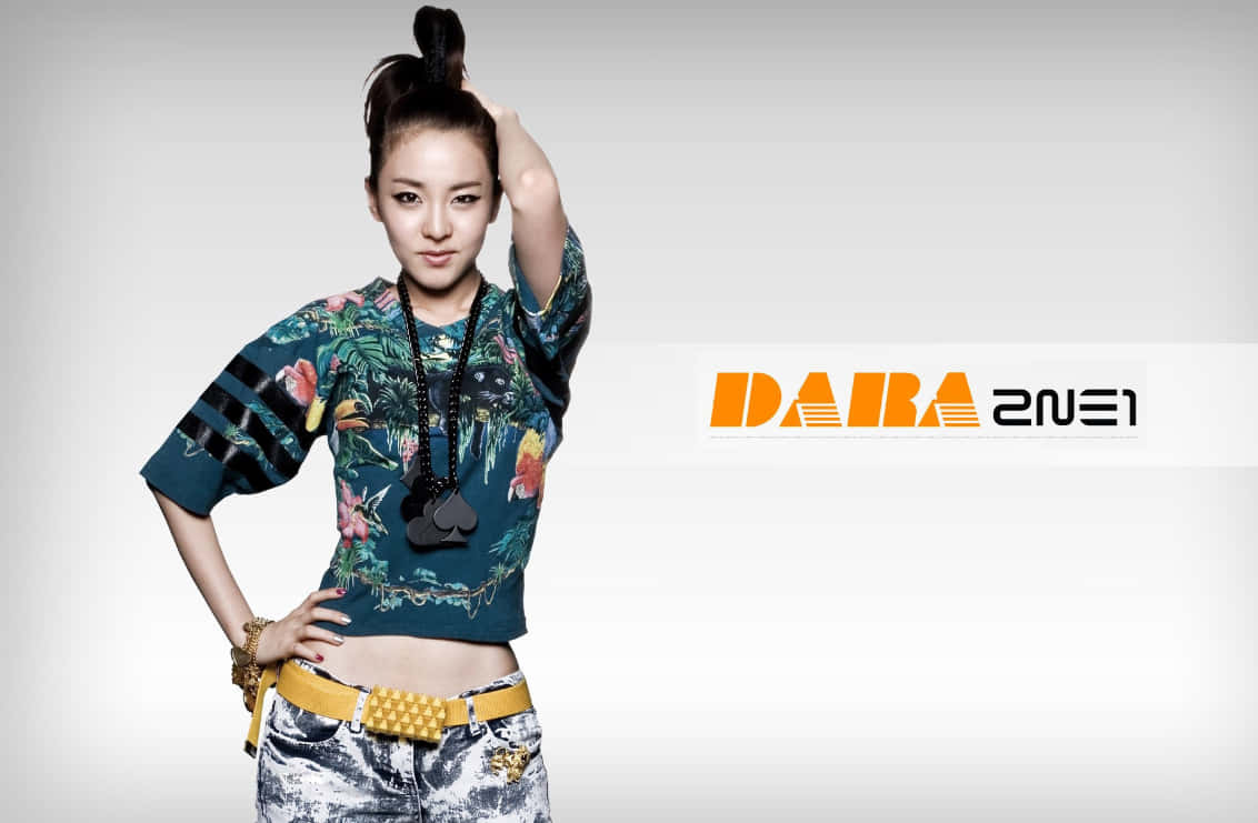 K-pop 藝人 Dara 穿著熱帶印花短版上衣和鉚釘腰帶擺姿勢。