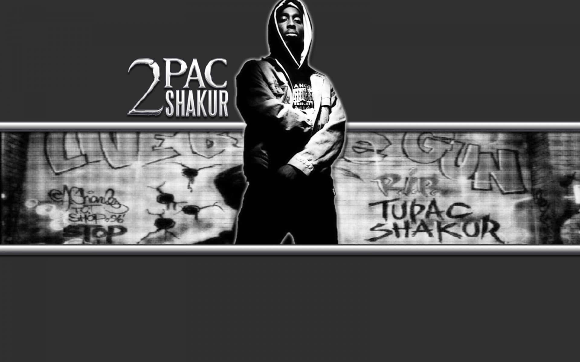 2Pac Shakur 塗鴉藝術圖 壁紙 — 一幅黑白肖像，Tupac Shakur 穿著連帽衫，站在佈滿塗鴉的牆前，牆上寫著「RIP TUPAC SHAKUR」。
