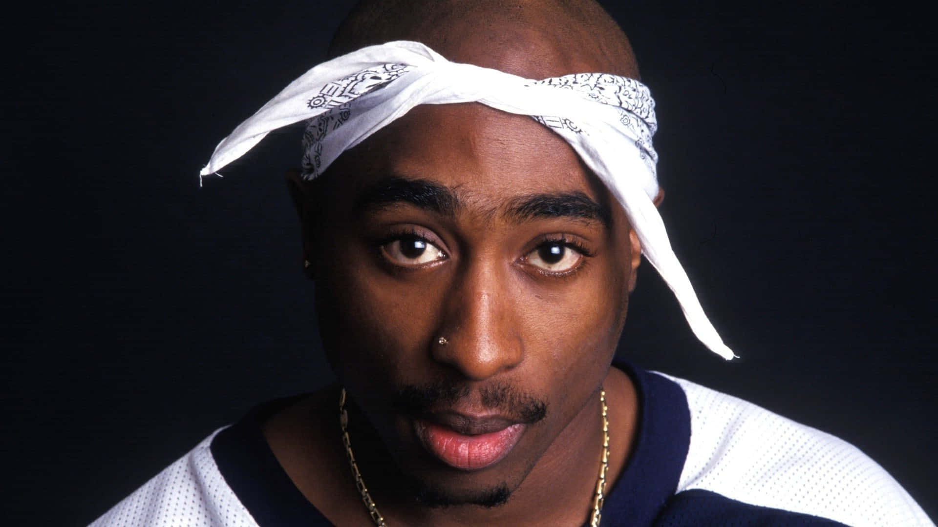 Tupac Shakur 喺影樓肖像中戴住白色頭巾同金鏈。