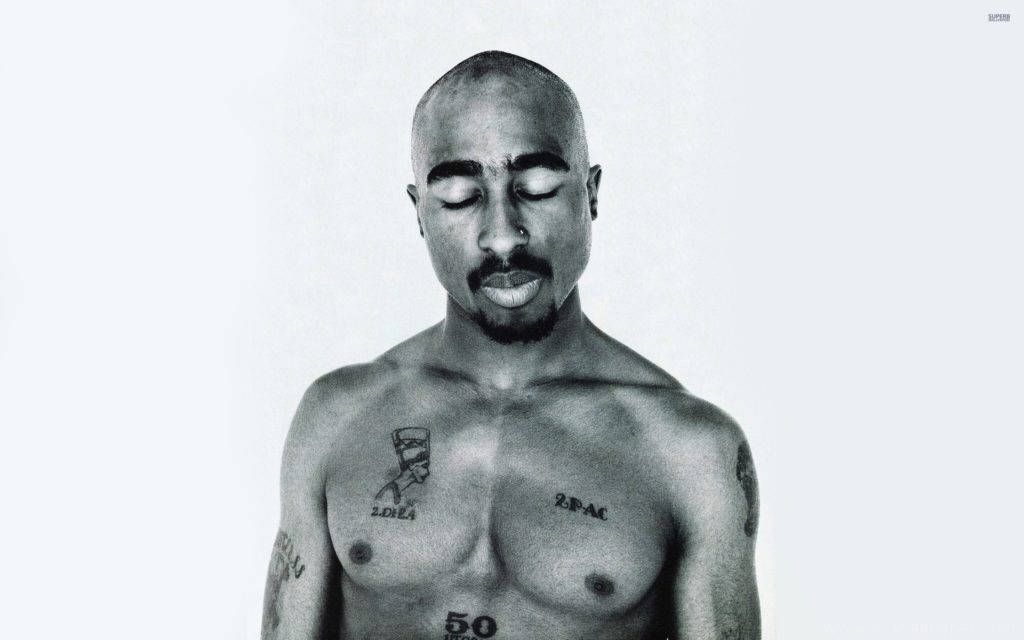 2Pac 裸胸閉眼 壁紙 — 一幅Tupac Shakur的黑白肖像，閉上眼睛，胸部和手臂上的紋身清晰可見，背景簡潔。