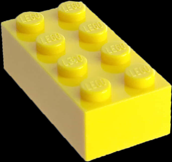 黃色樂高2x4積木 壁紙 — 一個明亮的黃色LEGO積木，有八個凸點，孤立地立在純黑色背景上。