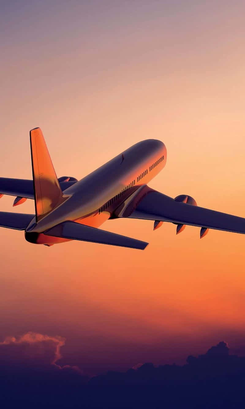 像素3小型飛機背景：日落天空 壁紙 — 一架商用飛機在充滿活力的橙色和紫色日落天空中翱翔，下方有柔軟的雲層。