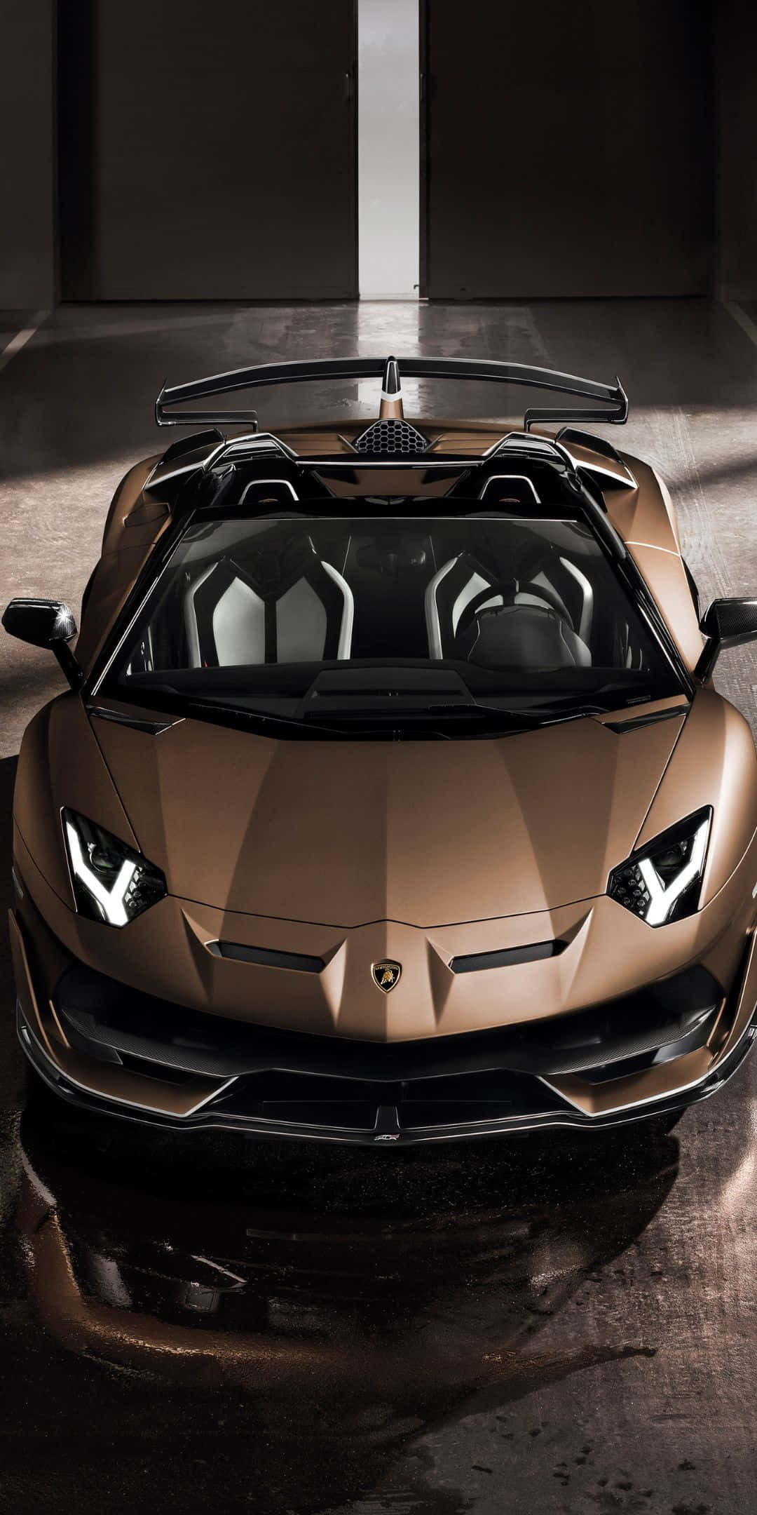 像素3蘭博基尼 — 奢華跑車壁紙 壁紙 — 一輛青銅色林寶堅尼 Aventador Roadster 在簡約時尚、帶有反光濕地板的車庫中，於戲劇性燈光下閃閃發光。