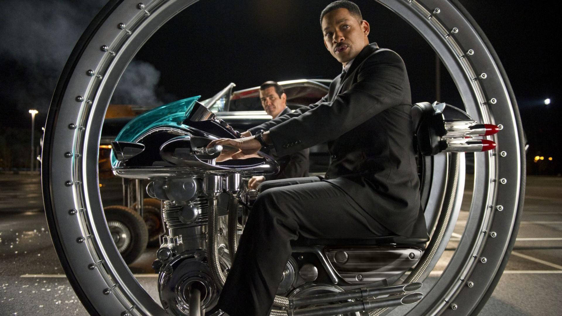 《黑衣人3》自行車 壁紙 — 韋史密夫在夜燈下騎著一輛鍍鉻電單車，被一個巨大的金屬環框住。