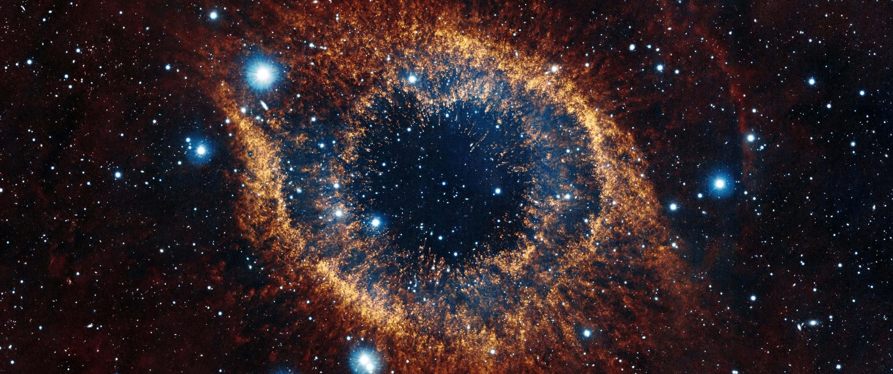 最佳3440x1440 HD高空之眼 壁紙 — 一個宇宙眼形星雲在星場中散發出火橙色和深藍色的光芒。