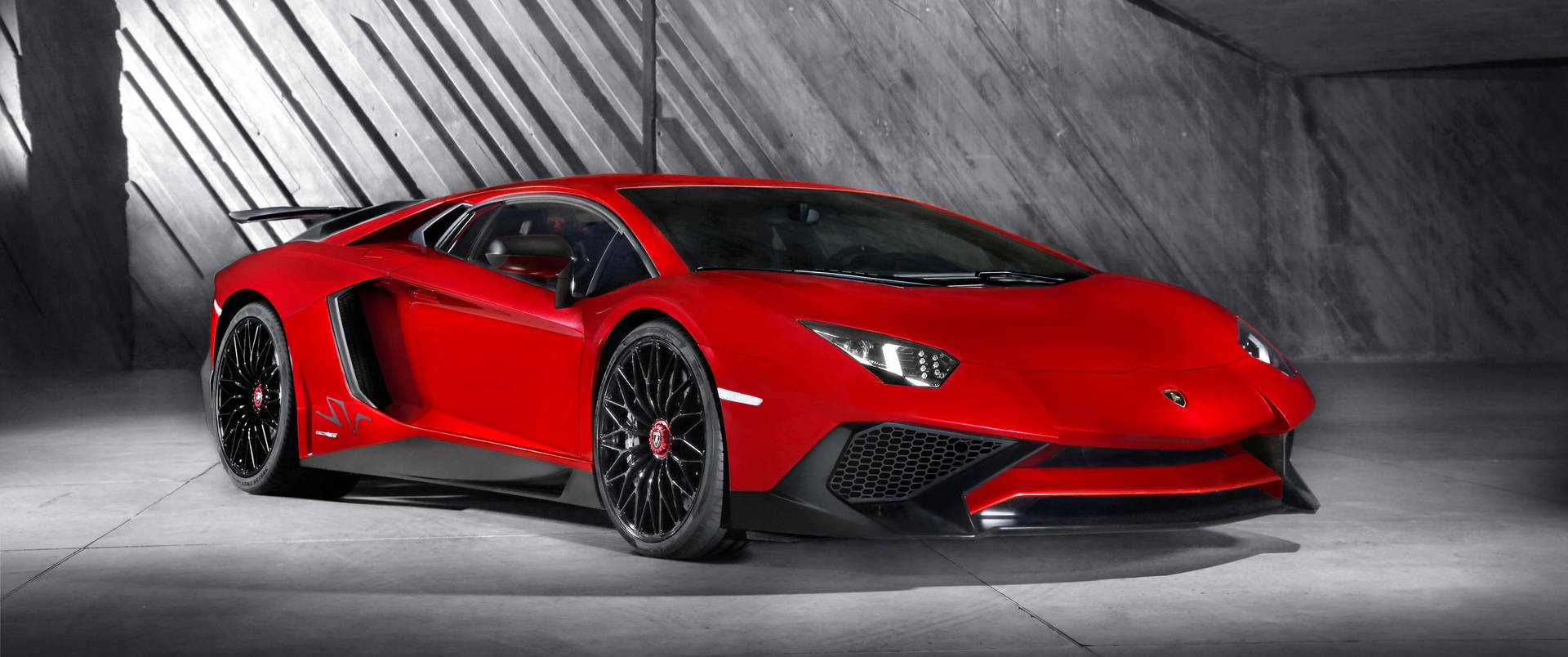 紅色林寶堅尼 Aventador SVJ 在現代混凝土車庫中，帶有戲劇性的燈光。