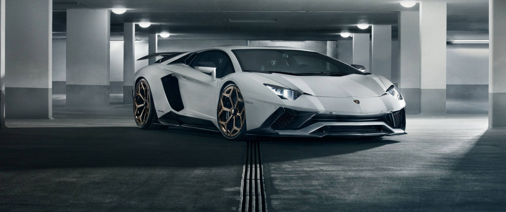 白色林寶堅尼Aventador配金色輪圈，在昏暗的停車場。