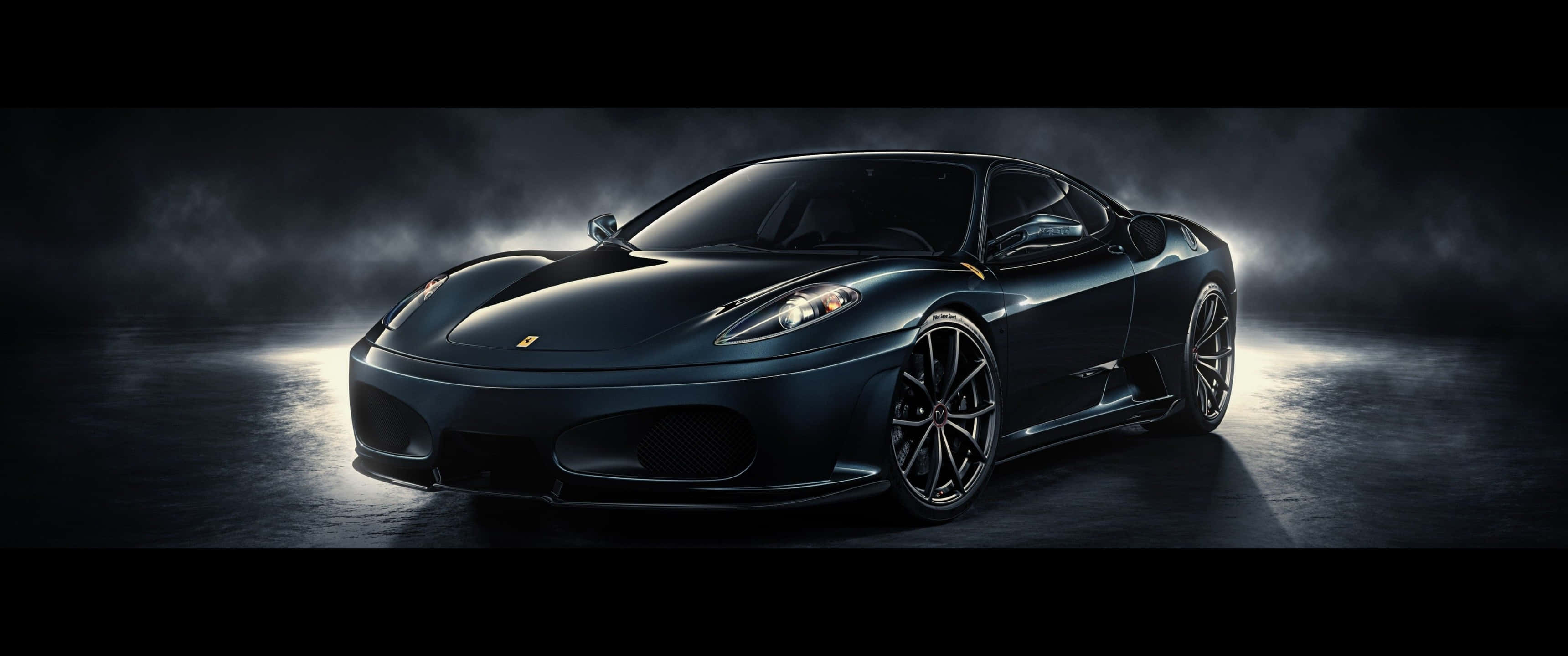 3440x1440p 法拉利430 Scuderia 黑色背景 壁紙 — 一架時尚的黑色法拉利跑車在煙霧瀰漫的昏暗工作室中，於戲劇性的聚光燈光束下閃耀。