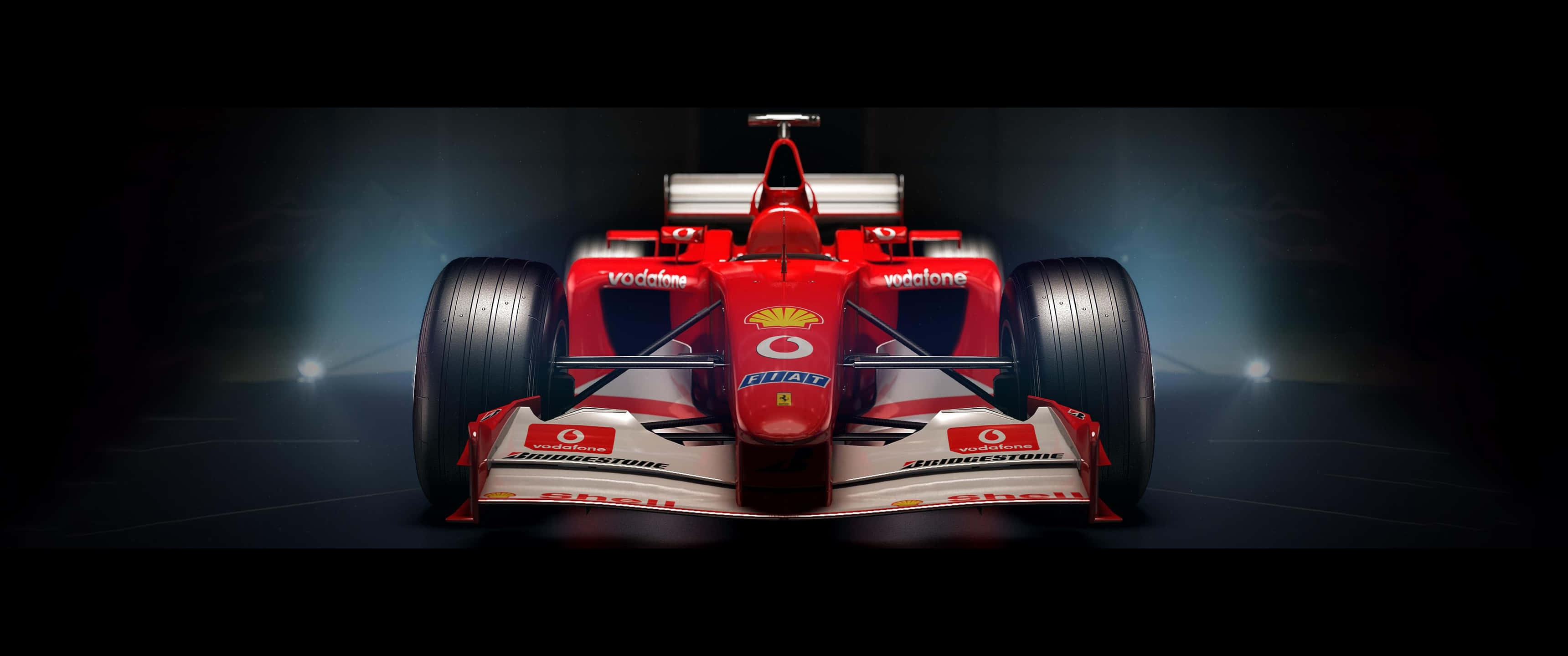 3440x1440p 法拉利F1遊戲背景 壁紙 — 一輛帶有Vodafone和Shell標誌的紅色法拉利F1賽車，在黑暗的舞台上被聚光燈從下方戲劇性地照亮。