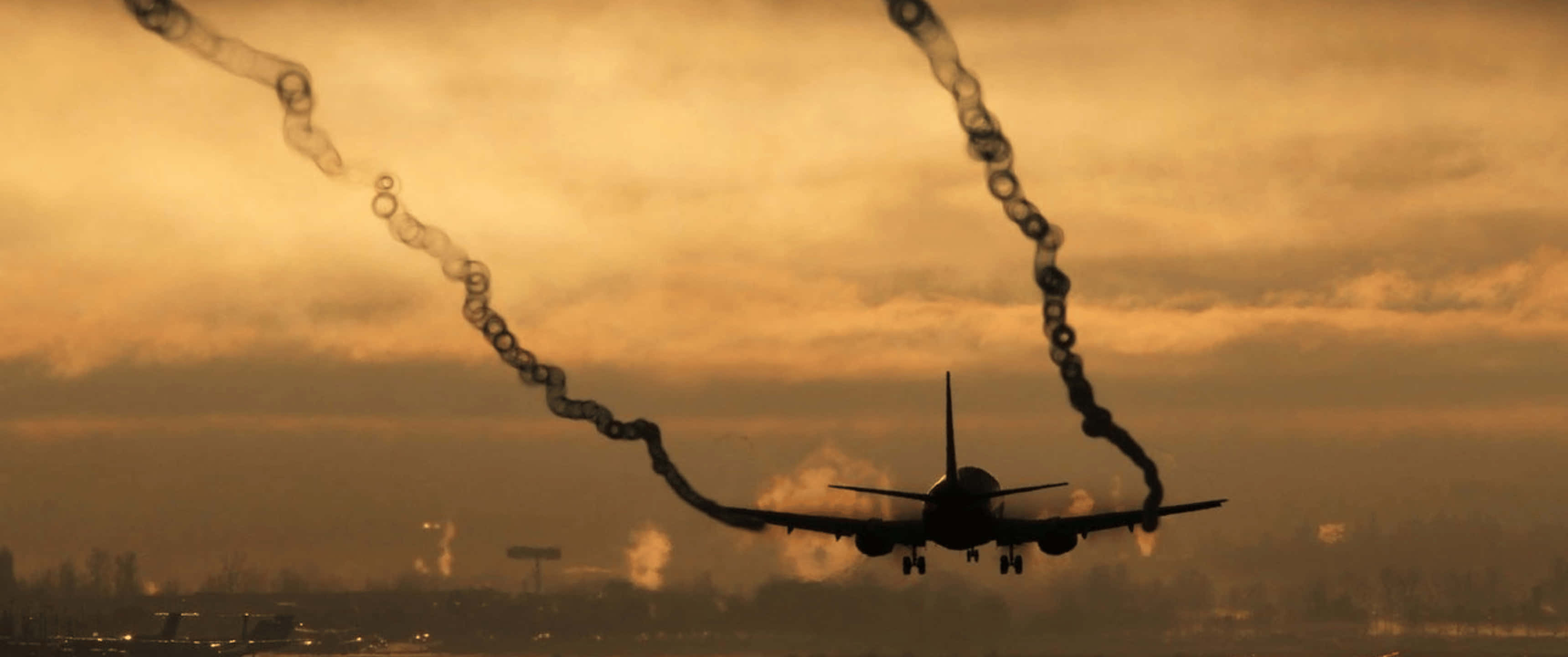 3440x1440p 飛機引擎冒煙降落背景 壁紙 — 一架噴射機在金色夕陽天空的襯托下呈現剪影，在降落時拖出環狀煙霧。
