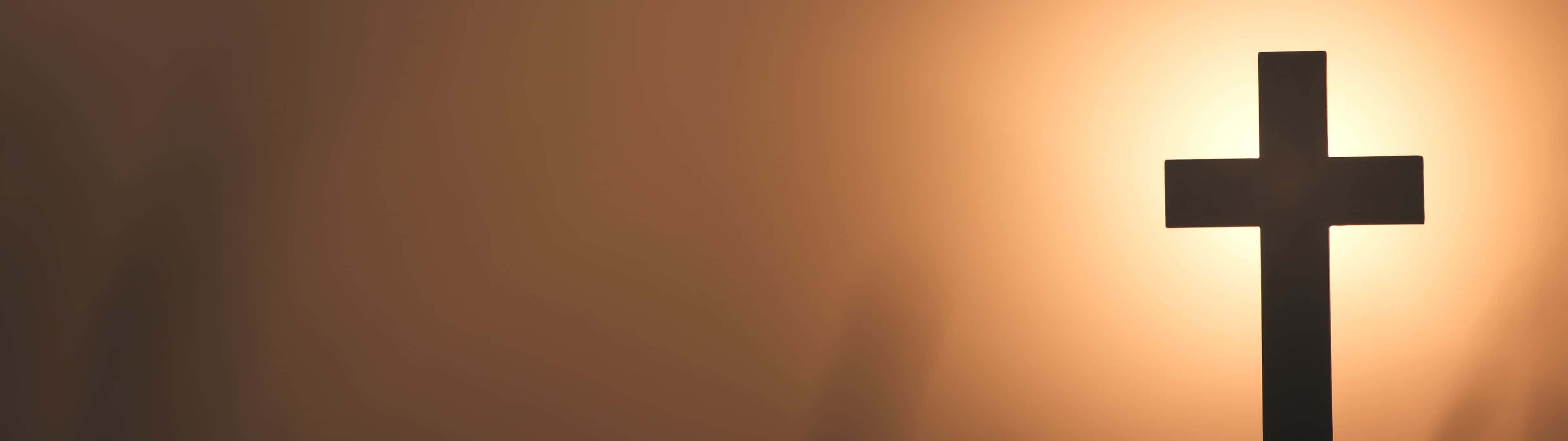 3840X1080 解析度的迷人數位畫作 壁紙 — 一個鮮明的黑色十字架剪影，映襯著溫暖發光的日落天空，帶有柔和的漸變色調。