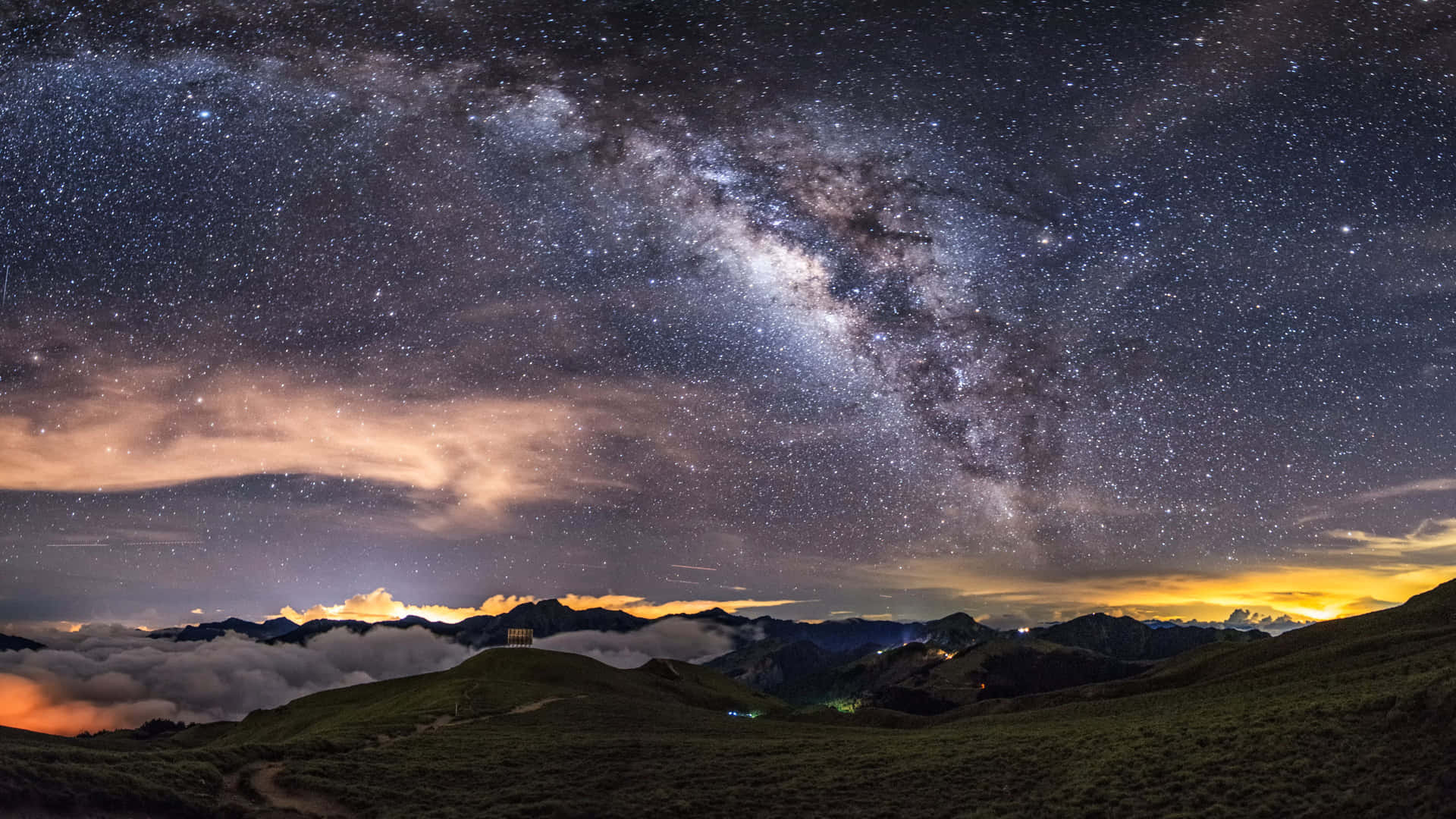 銀河系橫跨繁星點點的夜空，籠罩在山峰和雲海之上。