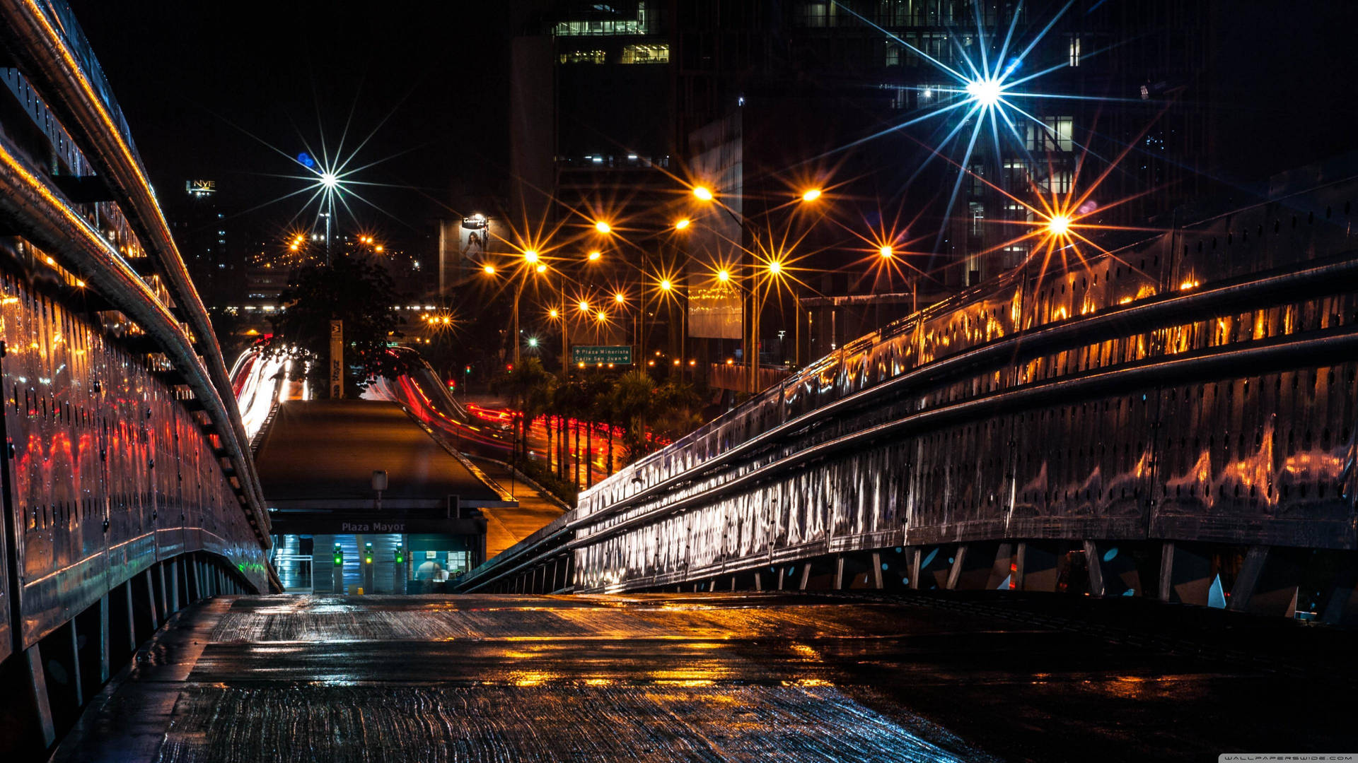 夜晚濕潤的城市橋樑，發光的街燈和汽車燈光條紋。