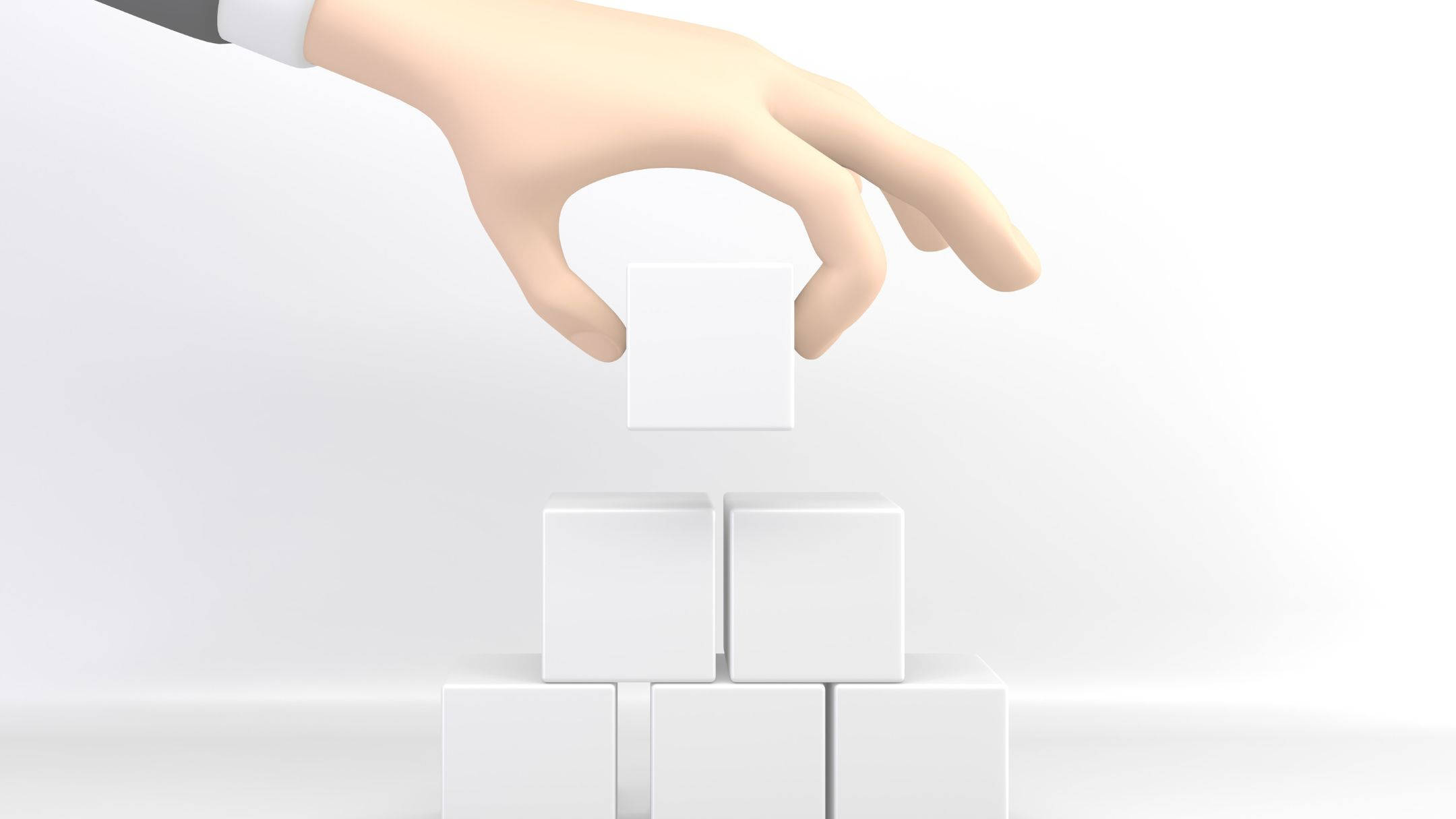 建築紙盒3D卡通數位藝術 壁紙 — 一隻穿著西裝袖的手將一個白色立方體放在一個由相同立方體組成的金字塔頂端，背景為簡約白色。