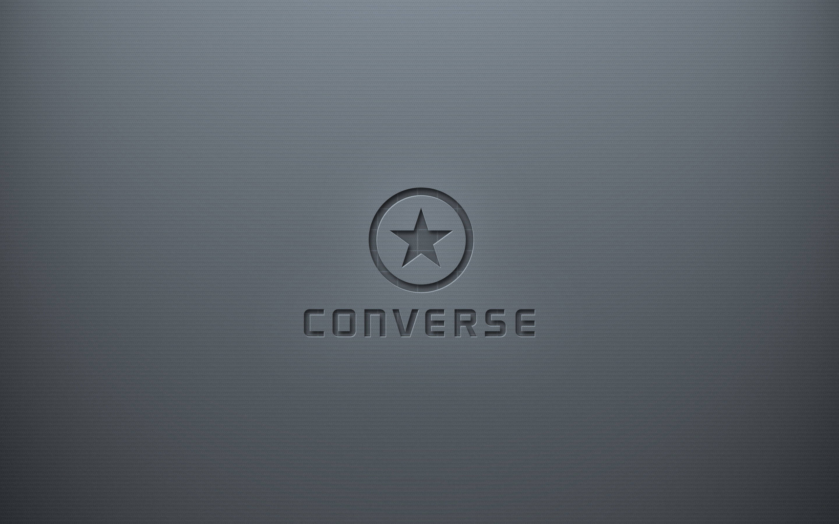 3D 灰色 Converse 標誌 壁紙 — 極簡深灰色紋理背景，帶有壓印的 Converse 標誌和品牌名稱。