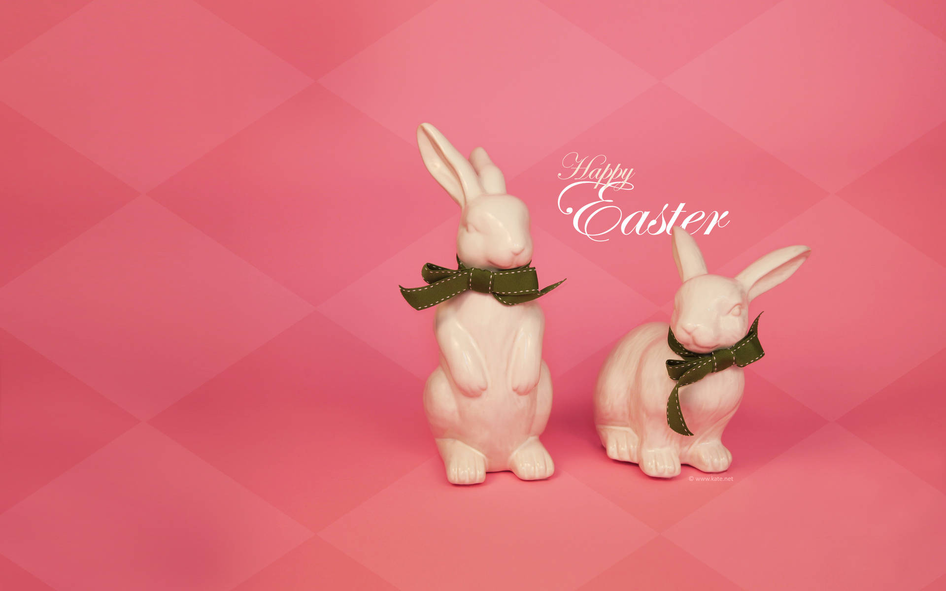 兩隻陶瓷復活節兔子繫著綠色蝴蝶結，粉紅色背景上有Happy Easter文字。