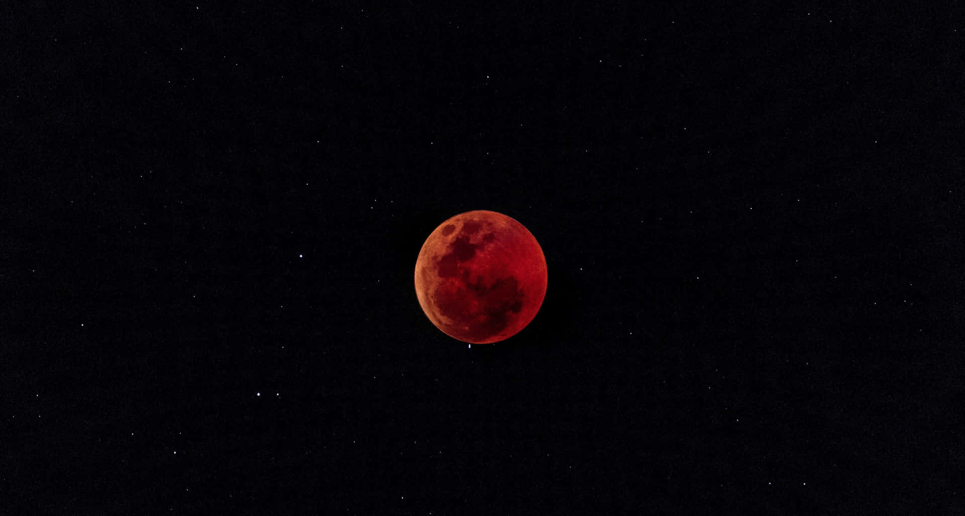 月食期間，血月在繁星點點的夜空中閃耀