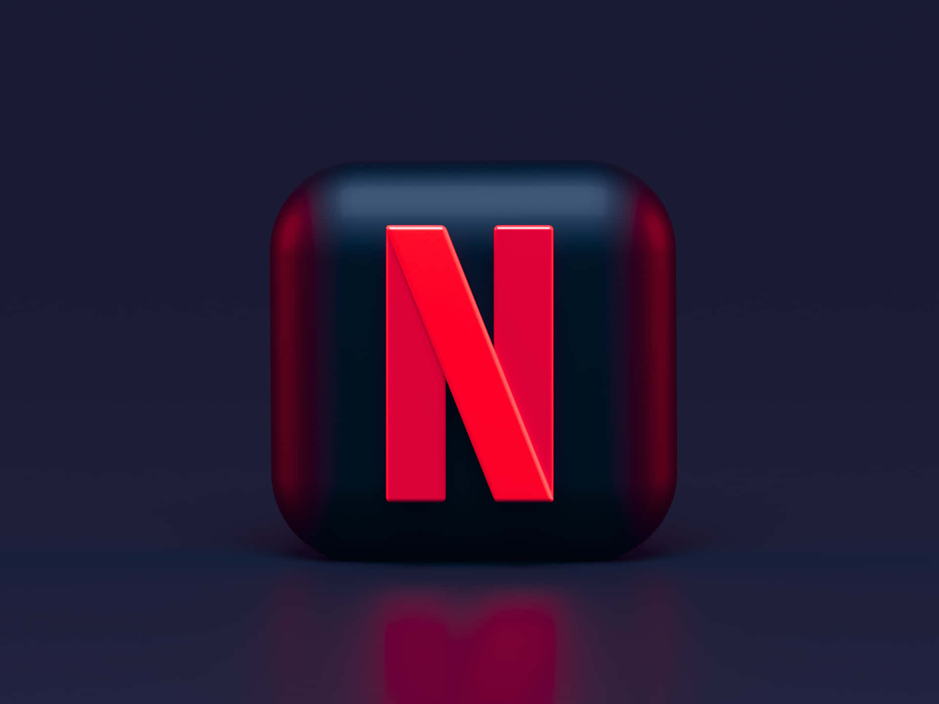 光滑黑色立方體，帶紅色Netflix標誌，置於深色反光表面。