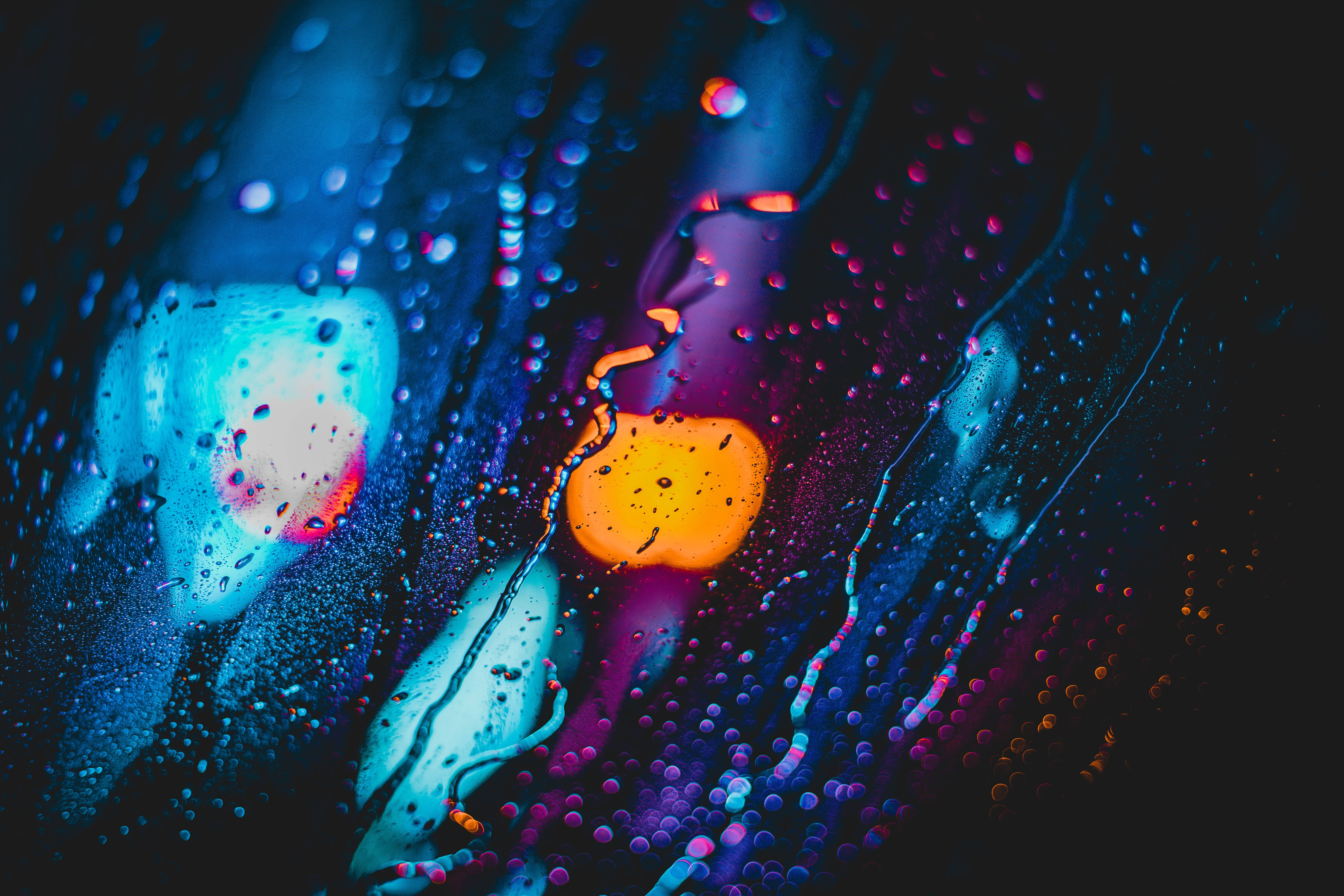 4D 超高清雨滴窗景 壁紙 — 充滿活力的霓虹色彩滲透被雨水打濕的玻璃，營造出帶有水滴和條紋的夢幻抽象光芒。