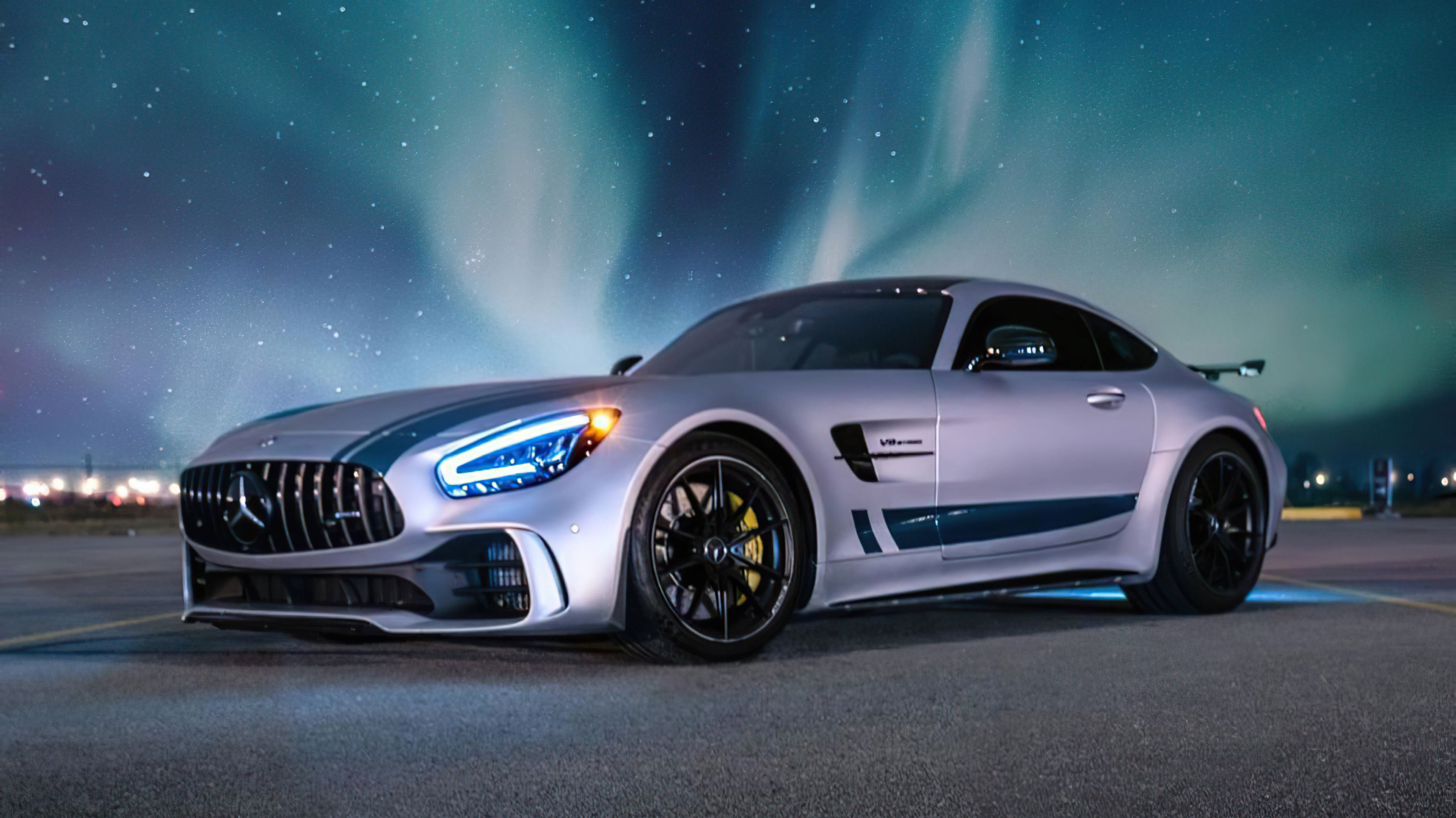4K 2021奔馳豪華車 壁紙 — 一輛銀色梅賽德斯-AMG GT Black Series跑車在繁星點點的夜空下，在絢麗的北極光下閃閃發光。