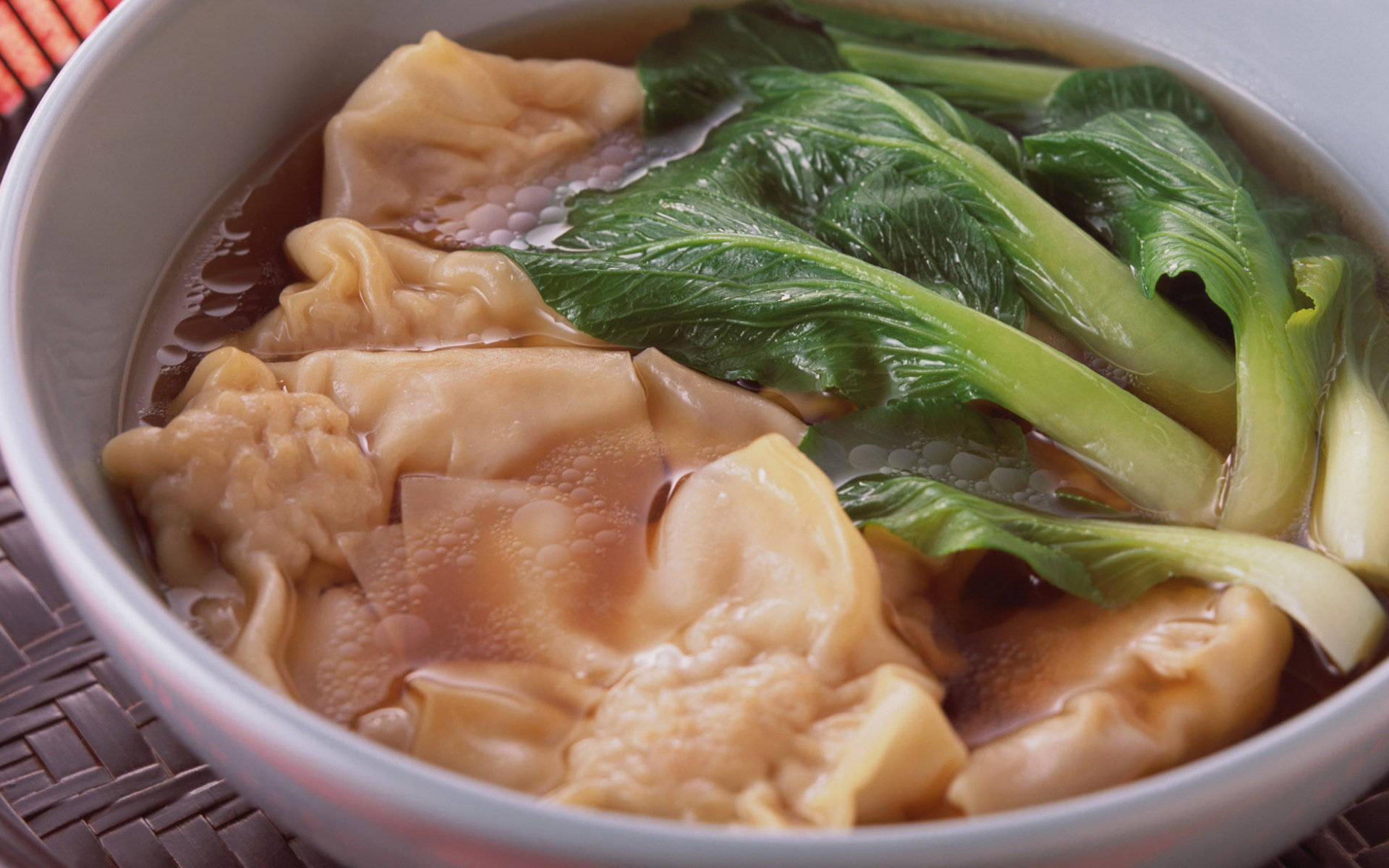 4K 食物餛飩湯 壁紙 — 一碗熱騰騰的雲吞湯，配上嫩滑的雲吞和新鮮的青菜，湯底濃郁。