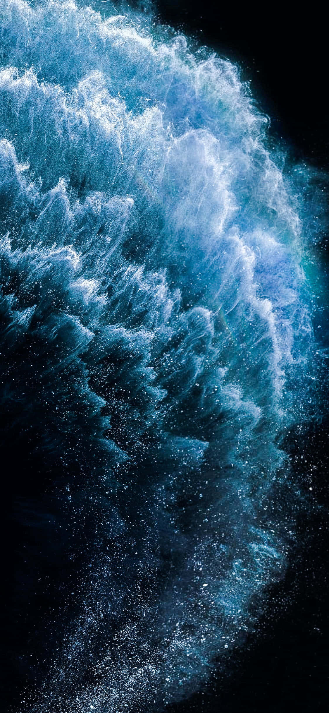 4K AMOLED 背景：浪花拍打紋理 壁紙 — 一道高聳的藍色波浪衝破黑暗，帶著泡沫般的白色飛沫和閃閃發光的水滴，定格在運動中。