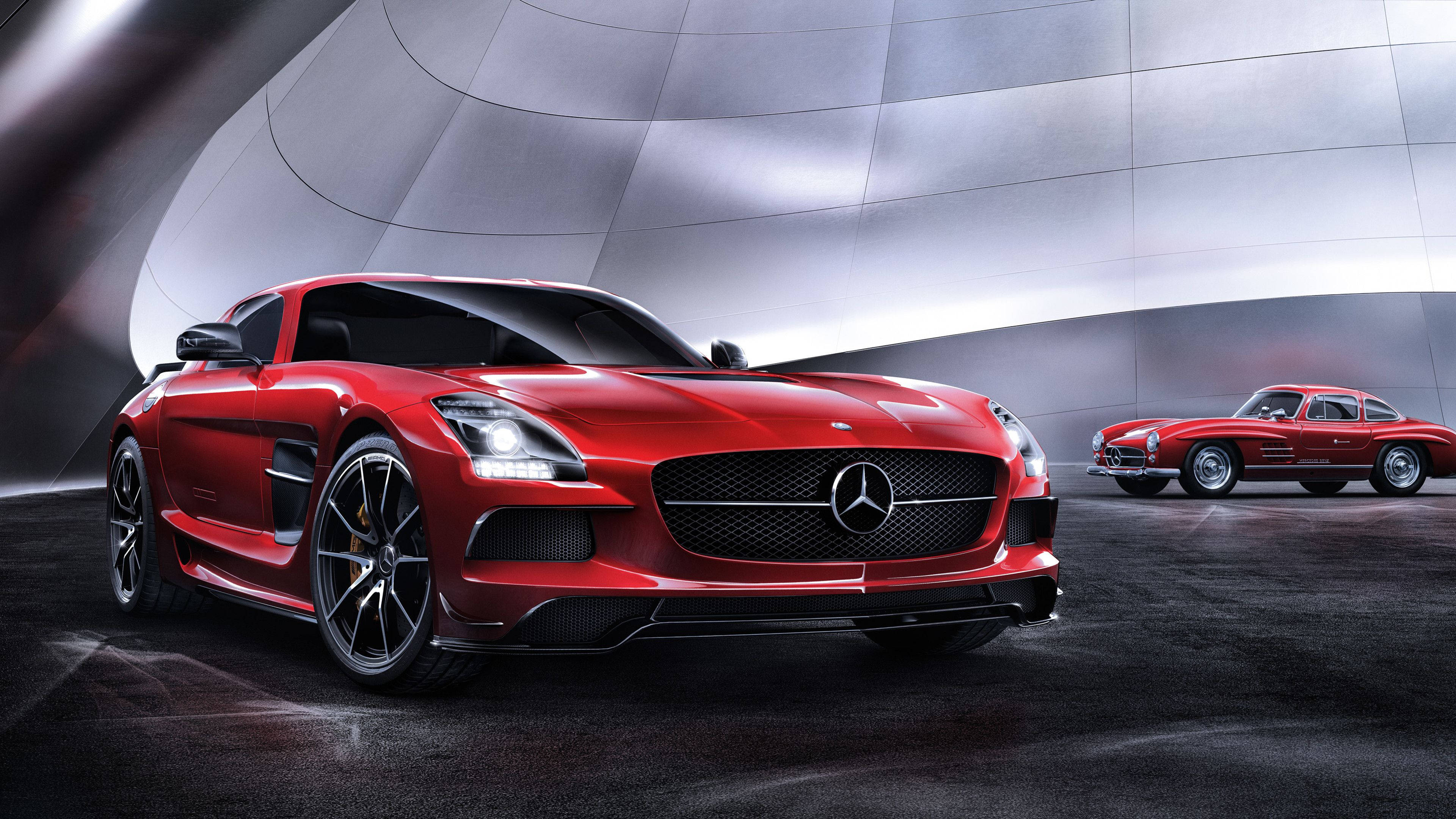 4K 奔馳 Black Series 壁紙 — 一輛時尚的紅色 Mercedes SLS AMG 跑車在未來感金屬隧道中，於攝影棚燈光下閃耀，旁邊是一輛經典的紅色 Mercedes 300 SL Gullwing。