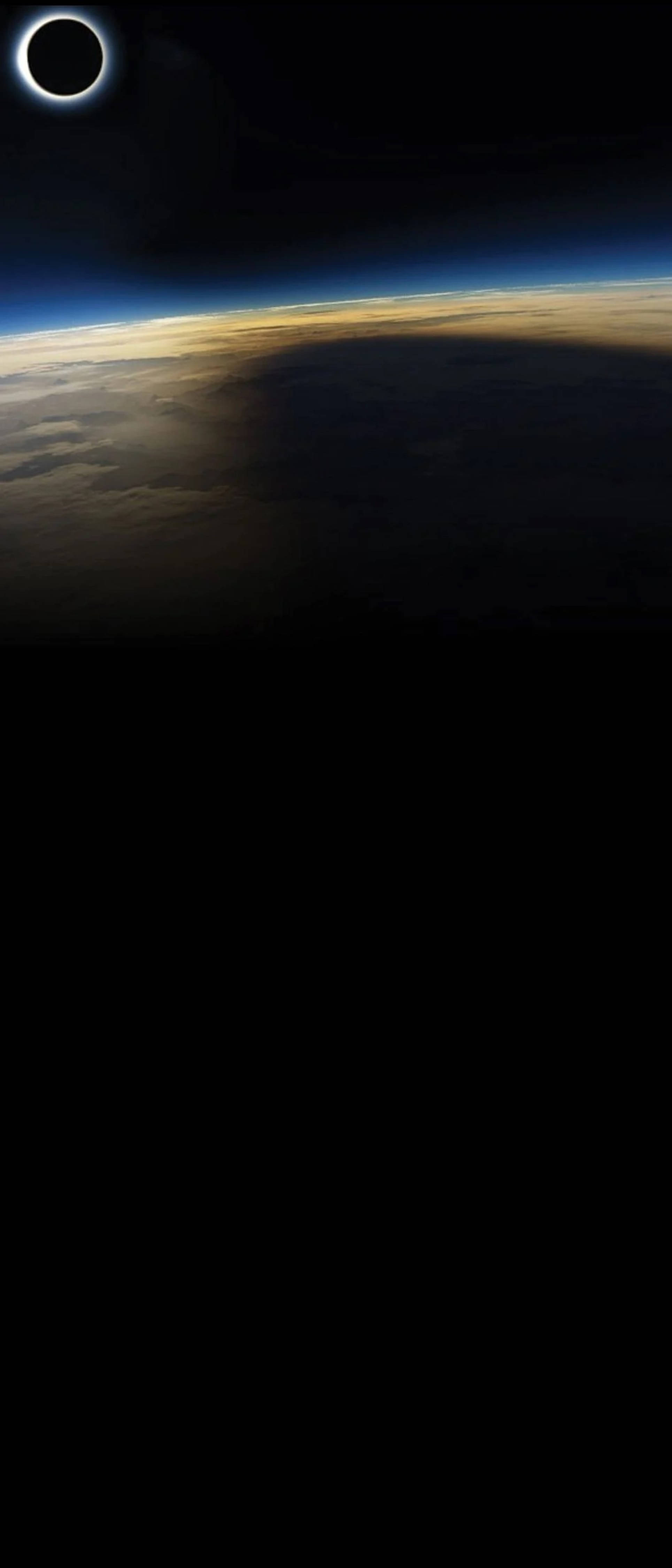 劇烈暗色地球 - 啟孔 4K 壁紙 — 從太空觀看日食期間地球的壯麗景色，月球周圍有發光的光環。