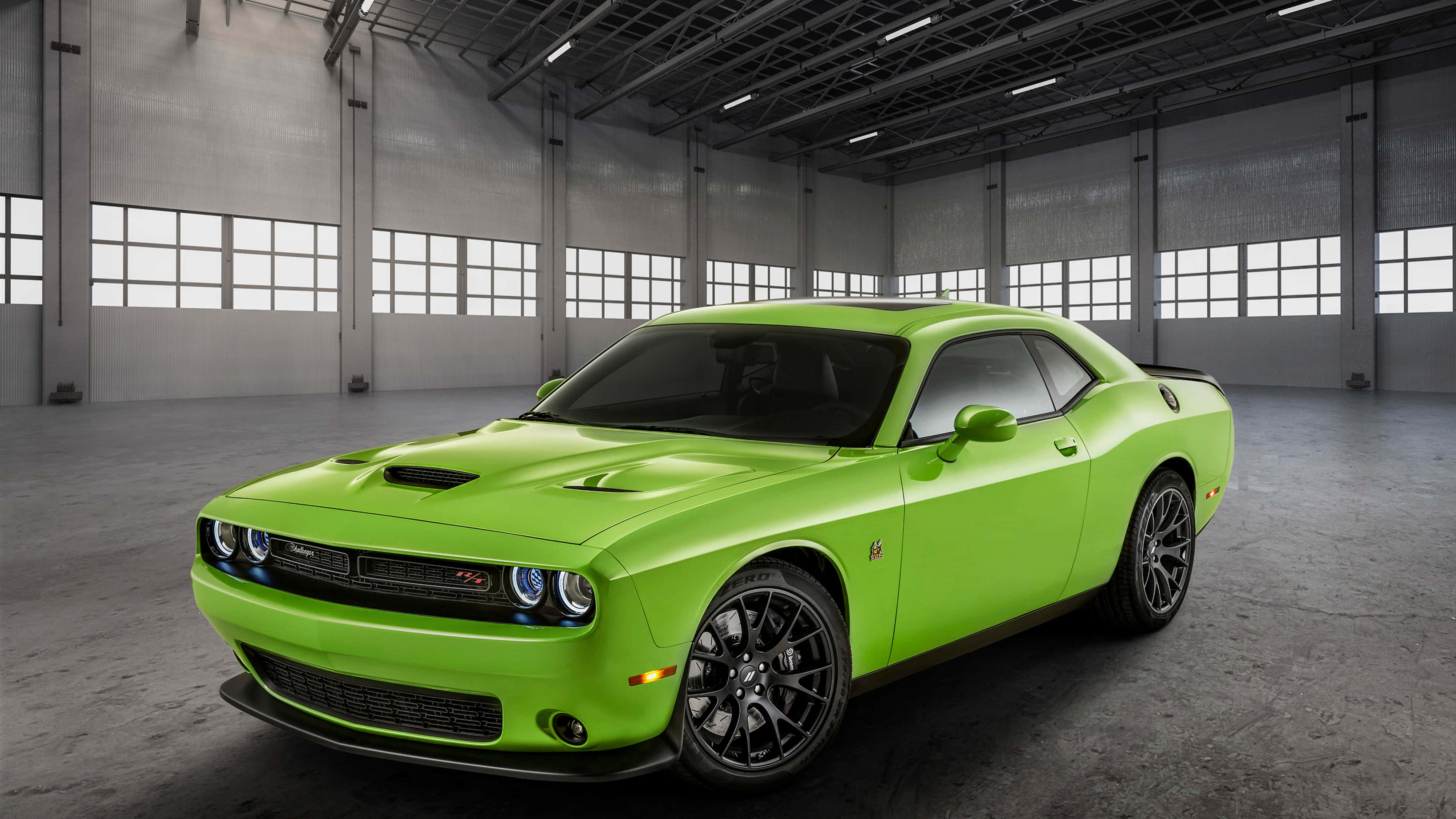 4K 柠檬綠Dodge Hellcat 壁紙 — 一輛充滿活力的青檸綠色道奇挑戰者SRT Hellcat停放在一個寬敞的工業倉庫中，倉庫有高窗和混凝土地板。