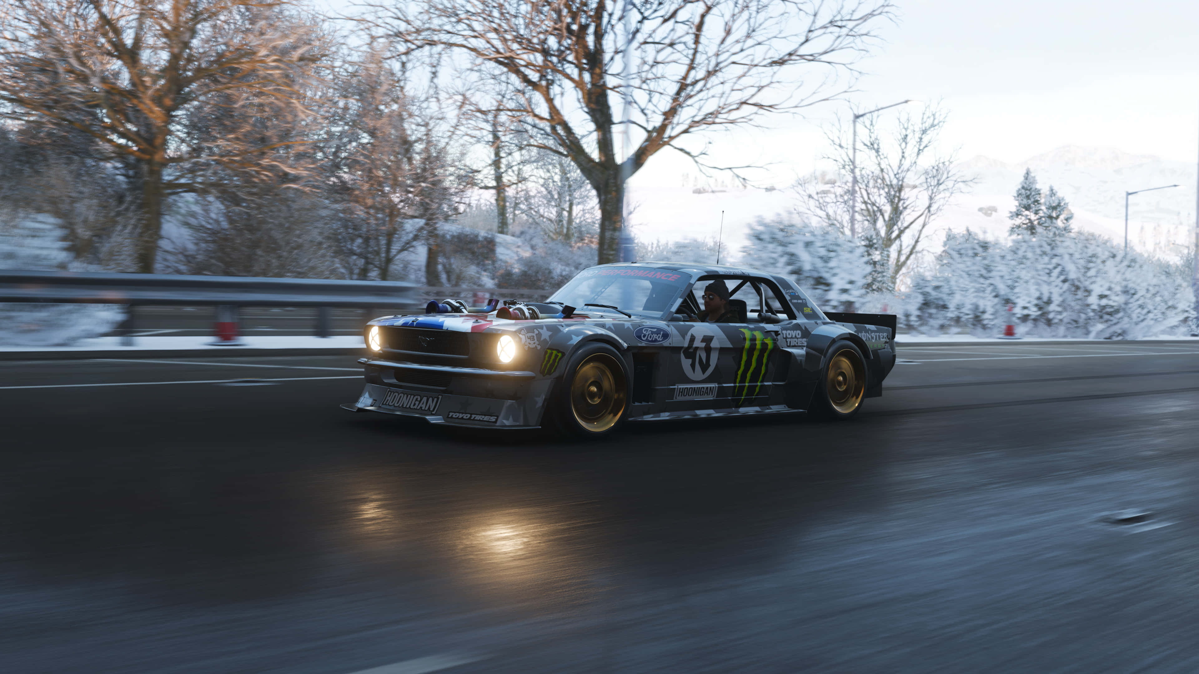4K《Forza Horizon 4》背景：賽道福特Mustang Hoonicorn 壁紙 — 一輛帶有Monster Energy塗裝的銀色賽車在黎明時分在積雪的山路上飄移。