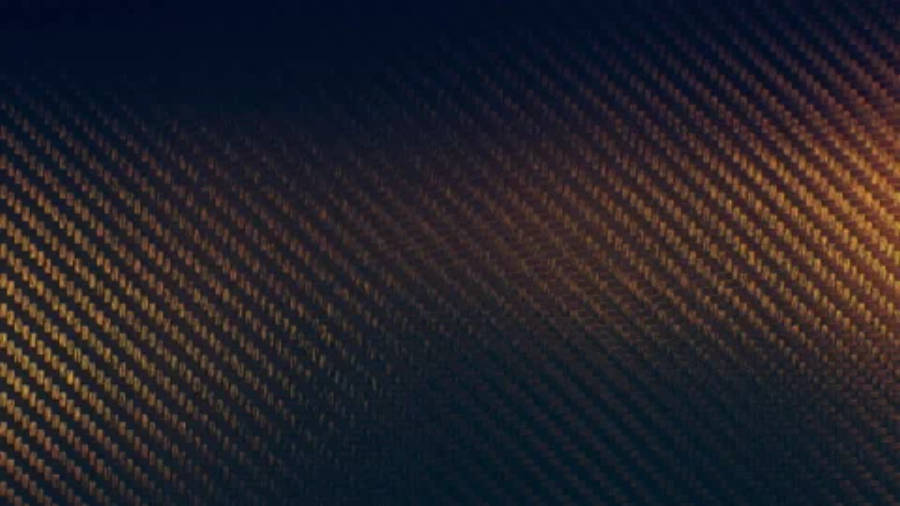 精緻 4K 碳纖維紋理 壁紙 — 從深藍到暖金色的對角碳纖維紋理漸變，帶有細微的光線條紋。