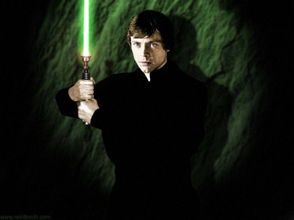 星際大戰 奧斯卡·路克·天行者 4K 持綠光劍 壁紙 — Luke Skywalker 在一個光線昏暗、帶有紋理綠色牆壁的洞穴中手持發光的綠色光劍，投射出戲劇性的陰影。