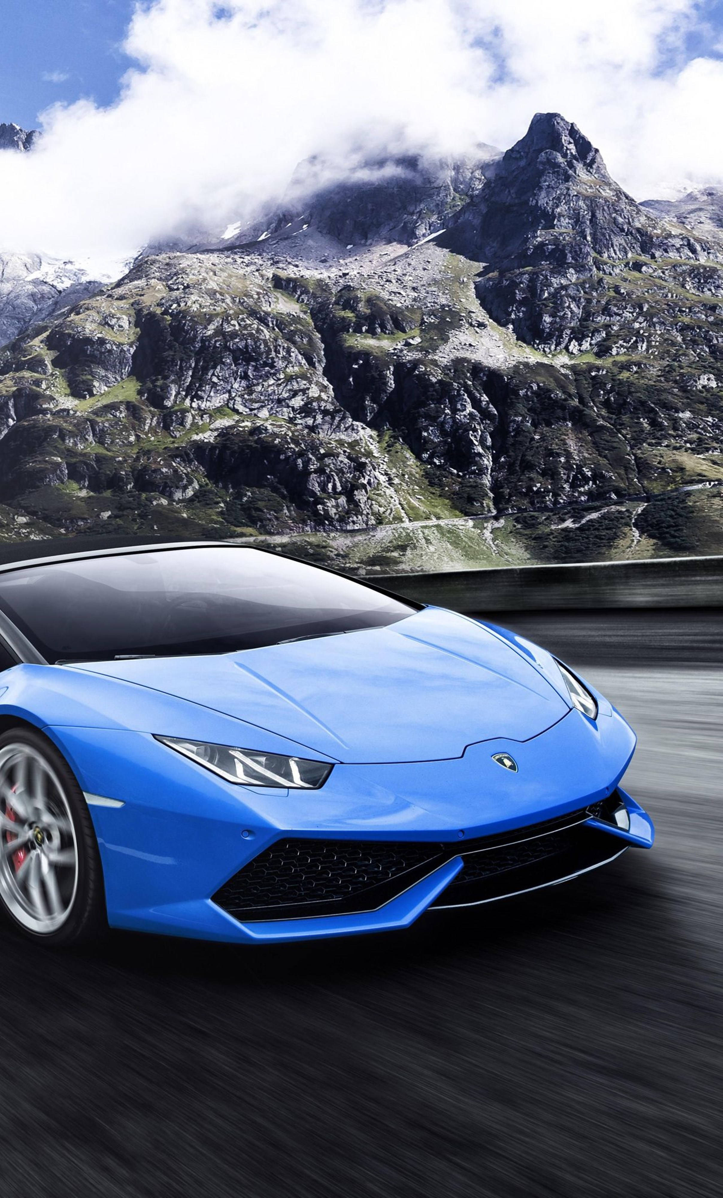 體驗4K解析度，感受Lamborghini的奢華 壁紙 — 一輛充滿活力的藍色林寶堅尼Huracán沿著山路疾馳，背景是白雪覆蓋的山峰和雲朵。