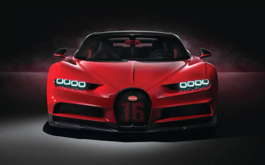 紅色布加迪奇龍 4K 壁紙 — 一輛引人注目的紅色Bugatti Chiron Super Sport 2020，帶有發光的頭燈和「16」標誌，在黑暗的攝影棚背景下戲劇性地照亮。