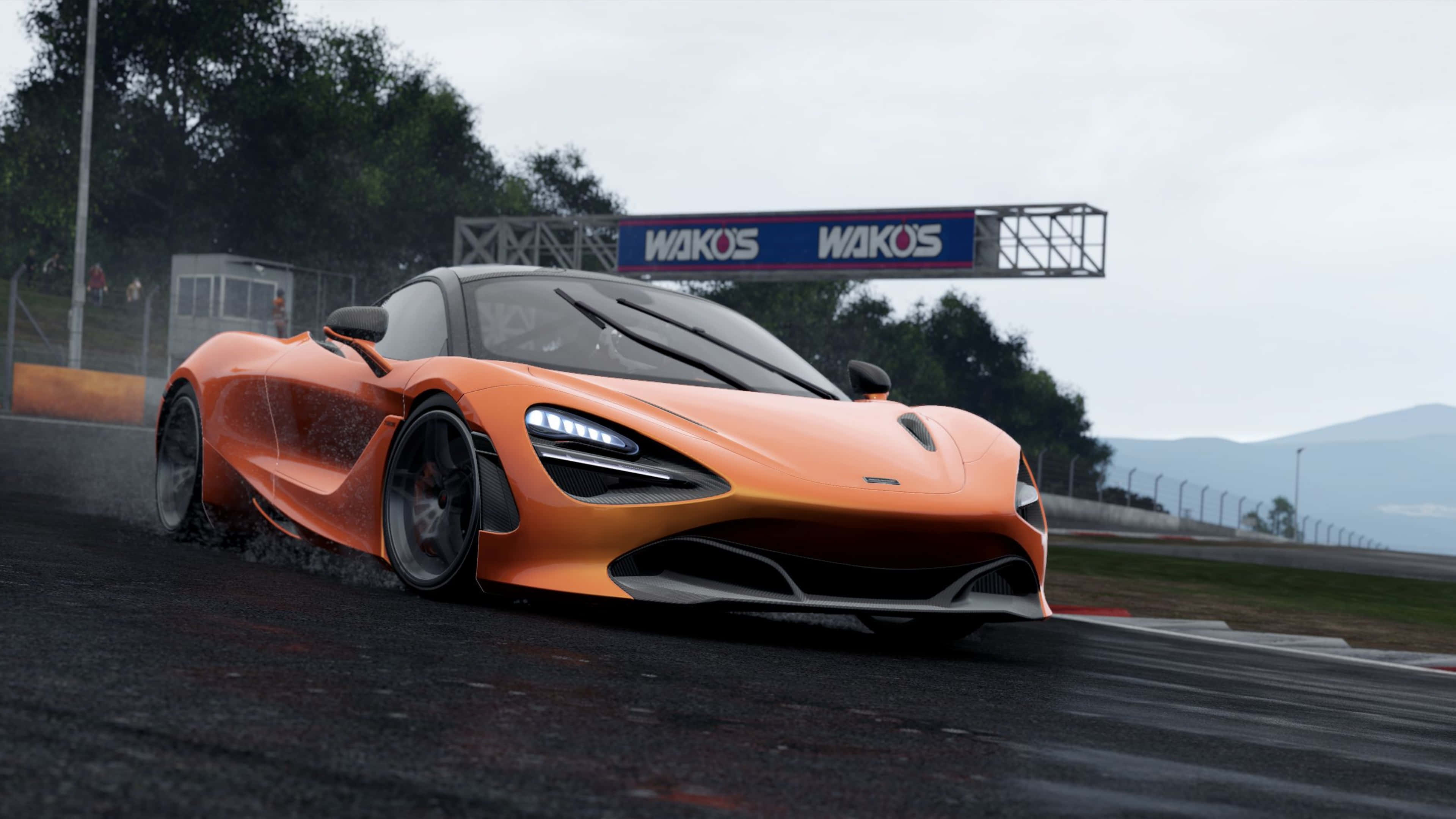 4K Project Cars 橙色 McLaren 720S 背景 壁紙 — 一輛鮮橙色的McLaren 720S在多雲的天空下，於潮濕的賽道上飄移，遠方有山脈，上方有'WAKOS'標誌。