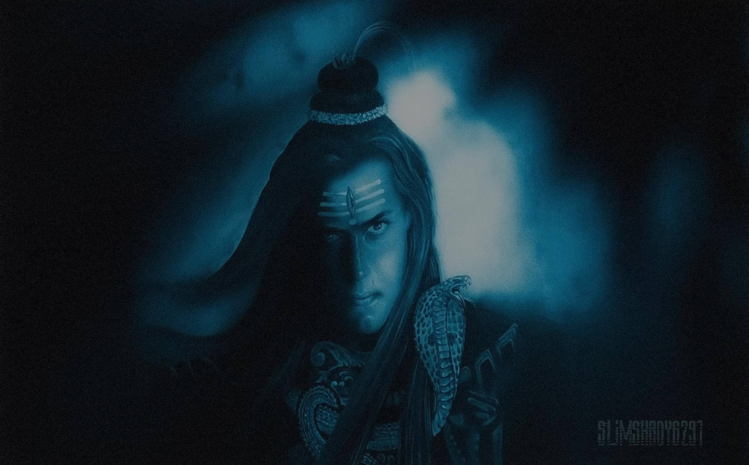 濕婆神 4K 藍色 壁紙 — 一位擁有長黑髮和額頭標記的戰士，在昏暗的藍色場景中，背後有發光的迷霧，專注地凝視。