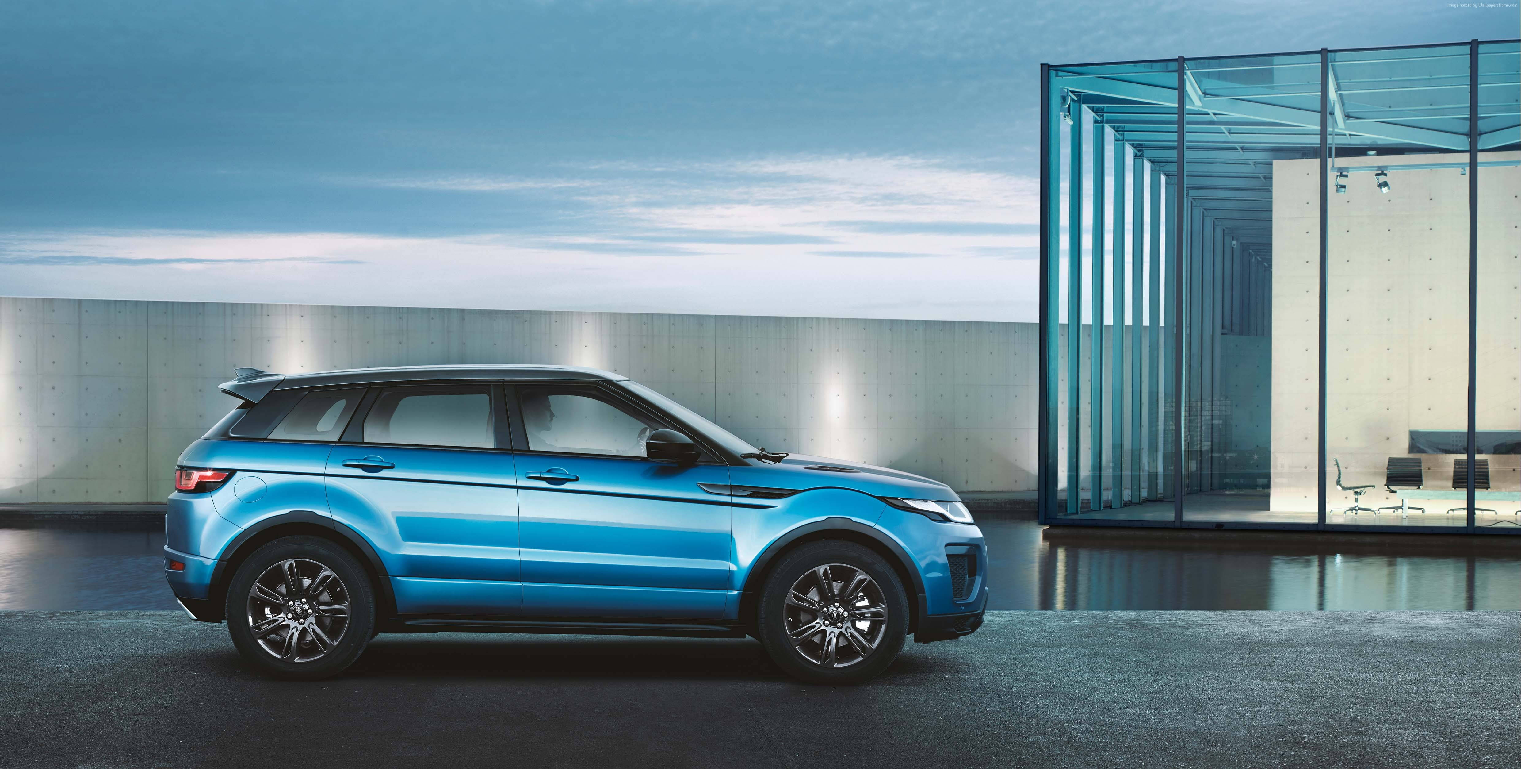 4K Range Rover 辦公室 壁紙 — 一架時尚的藍色SUV停泊在現代玻璃建築旁，背景是暮色天空。