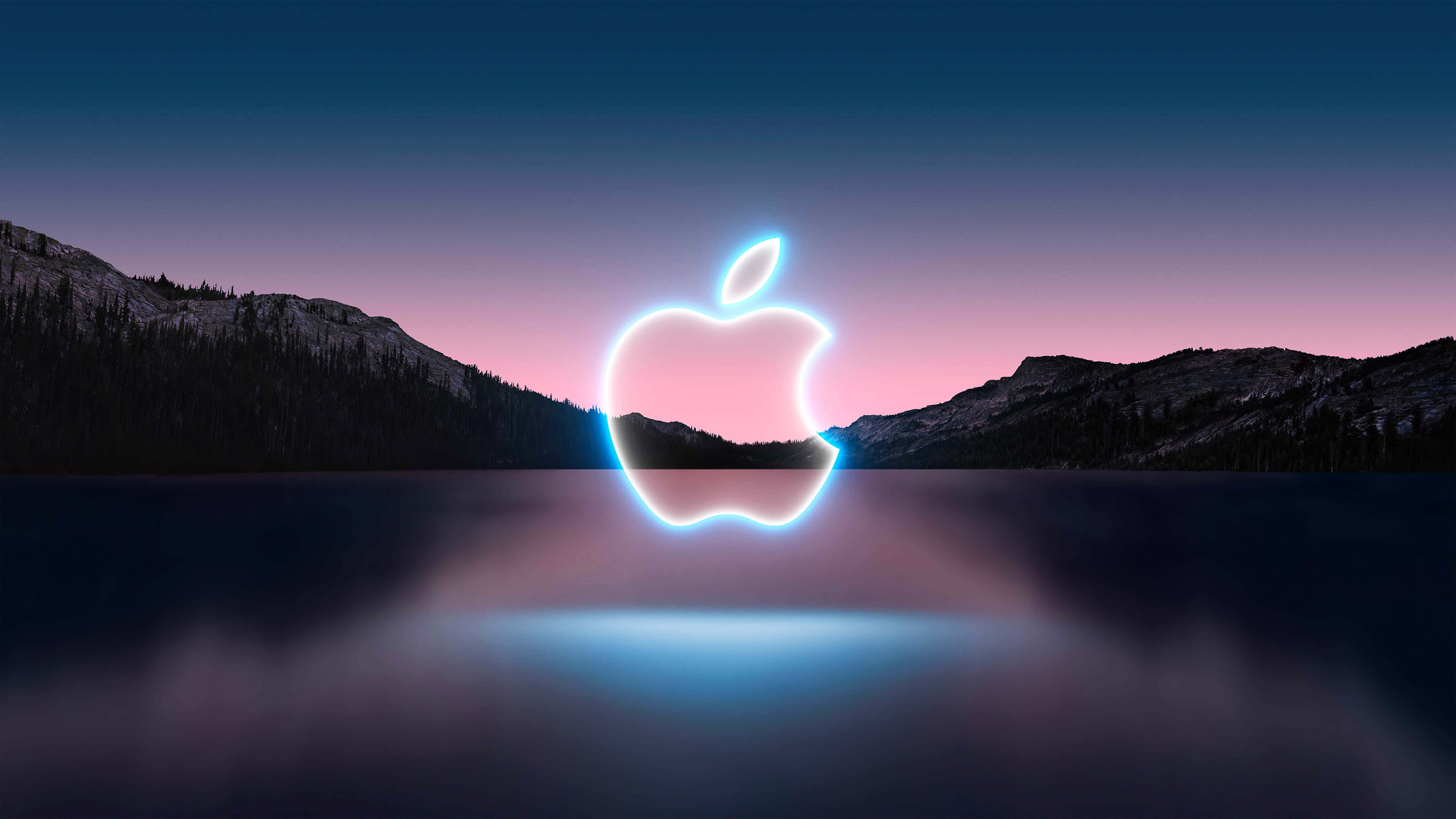 4K 蘋果與山脈 壁紙 — 一個發光的霓虹燈Apple標誌懸浮在黃昏時分的平靜湖面上，背景有山脈。
