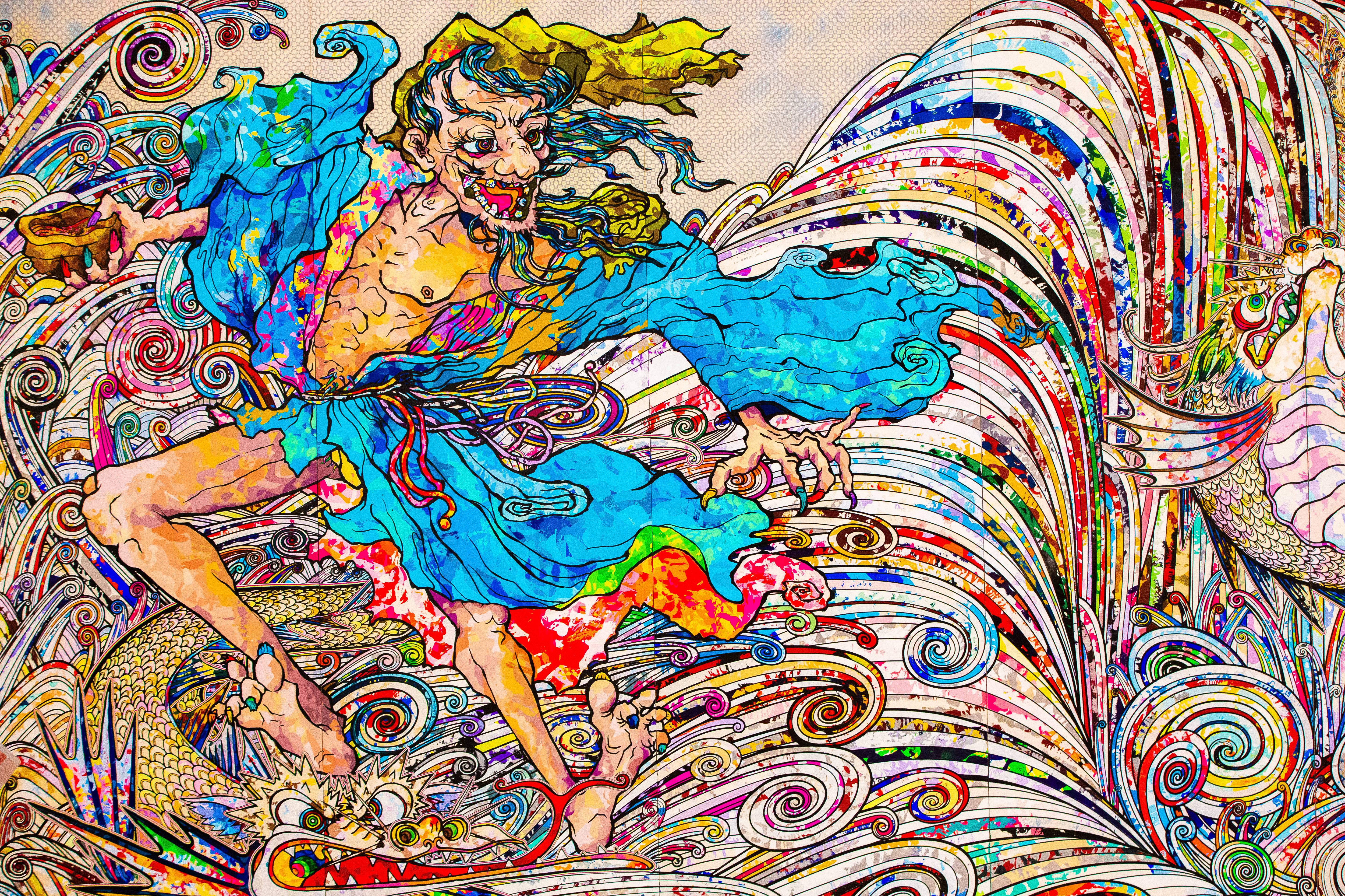 村上隆水鬼4K 壁紙 — 一幅充滿活力的動漫風格插圖，描繪了一個身穿藍色長袍、頭髮狂野、牙齒鋒利的兇猛惡魔，周圍環繞著旋轉的彩色圖案和一條龍。